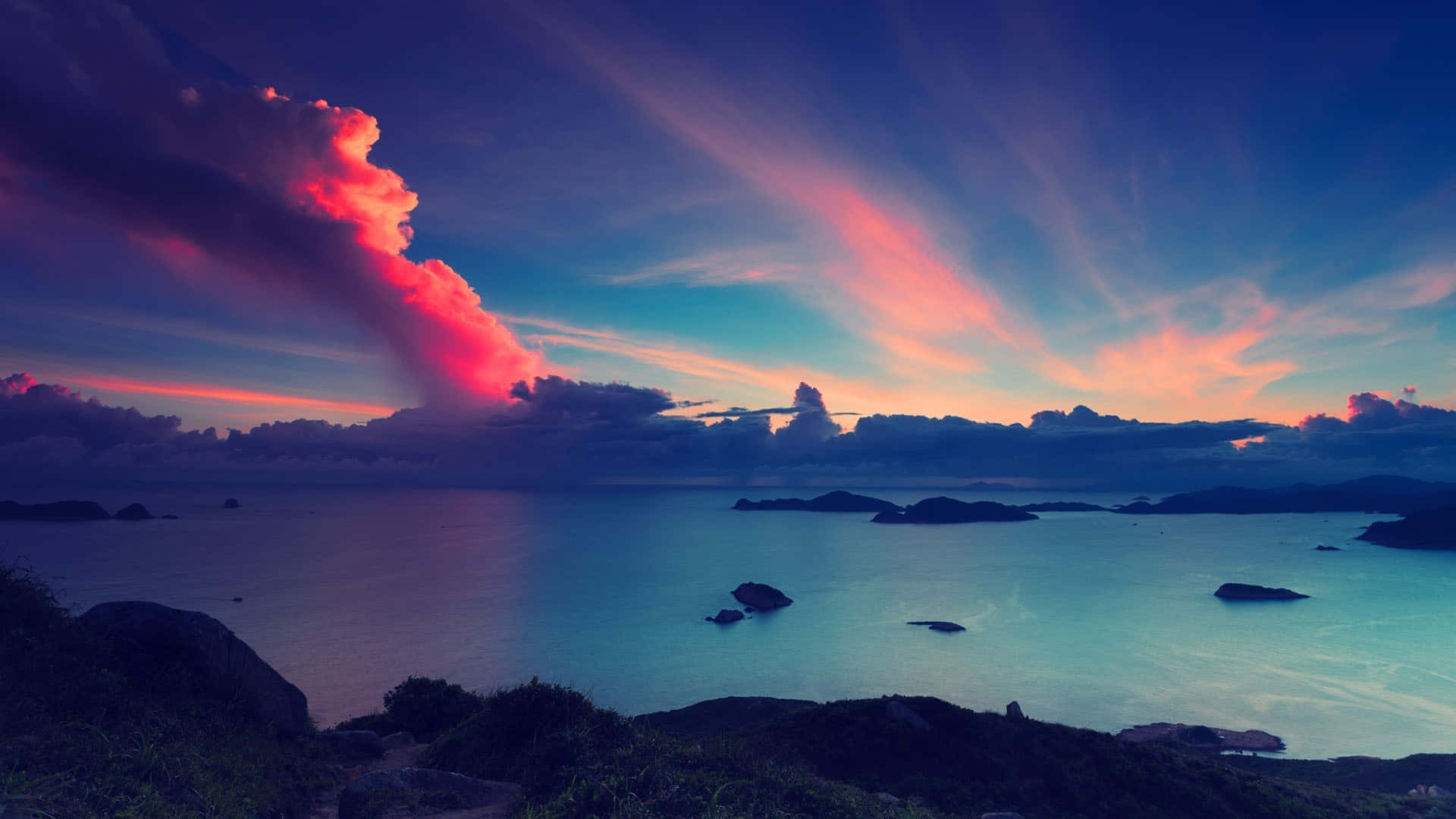 Soothing 桌布 壁紙 — 戲劇性的日落將天空染成火熱的粉紅色和深藍色，平靜的海面上點綴著輪廓分明的島嶼。