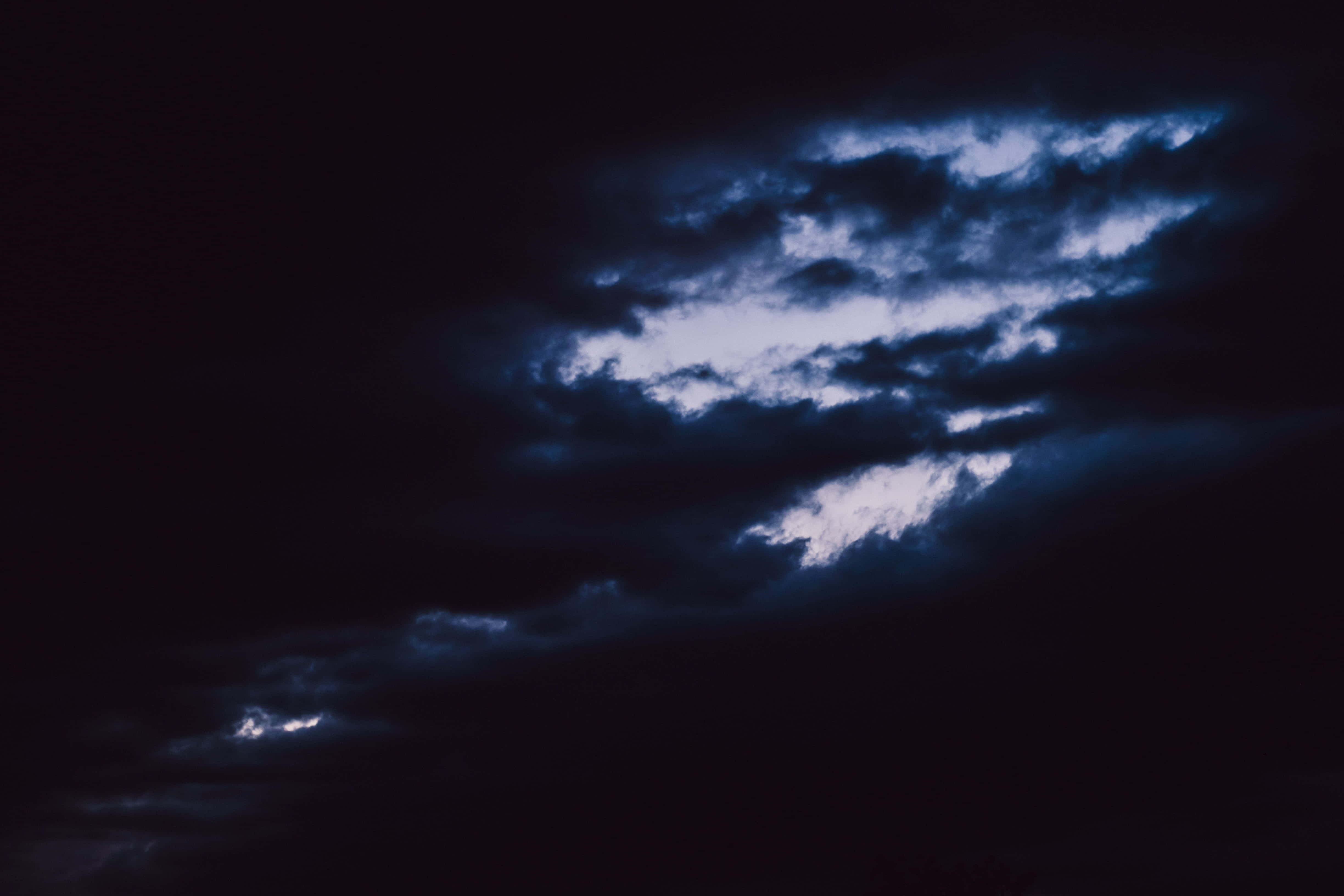 Dark Heaven 桌布 壁紙 — 戲劇性的深色雲朵在黑色天空中呈現深藍色和白色光芒。