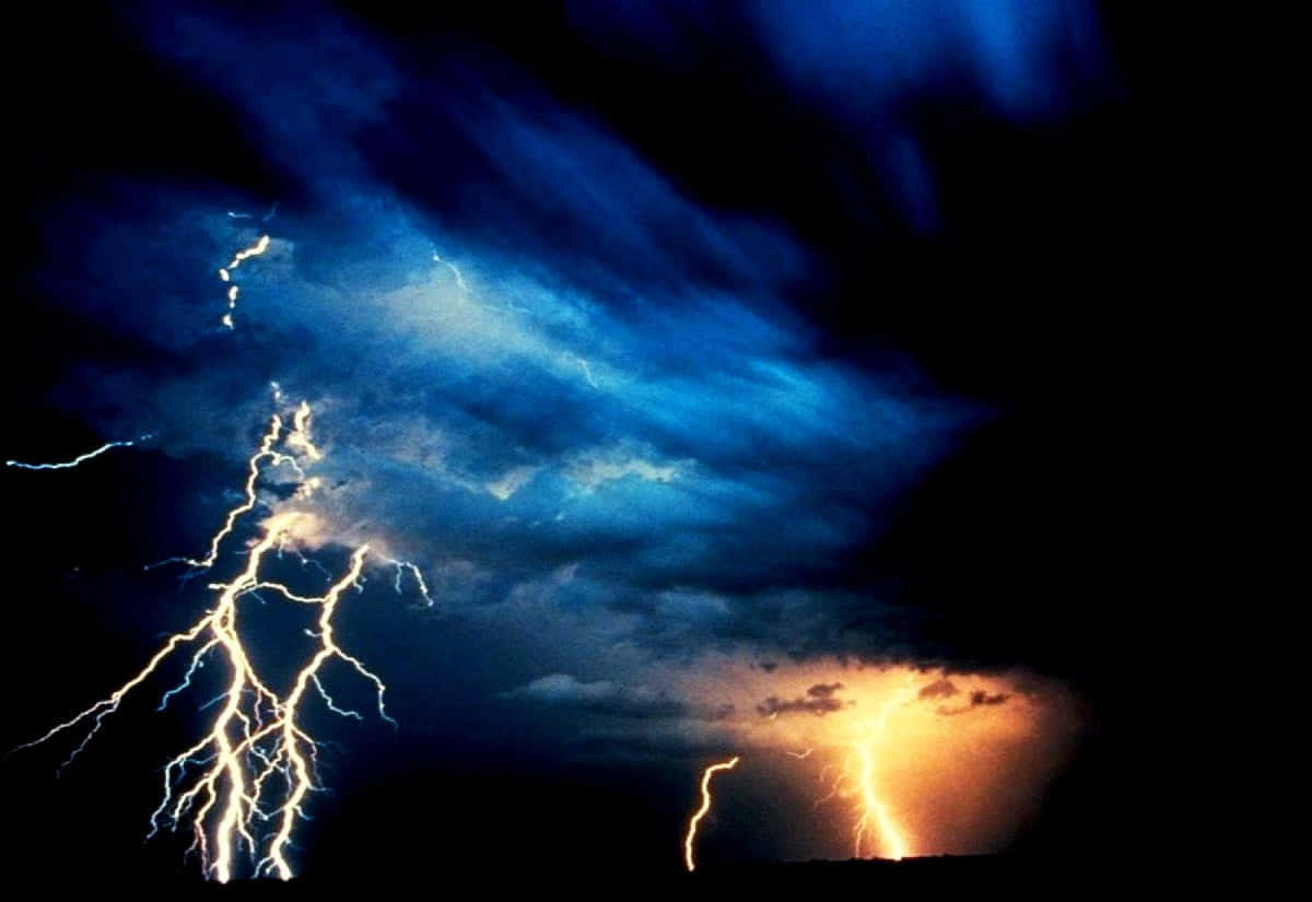 Thunderstorm 桌布 壁紙 — 戲劇性的閃電劃破黑暗地平線上方湍急的藍橙色暴風雨天空。