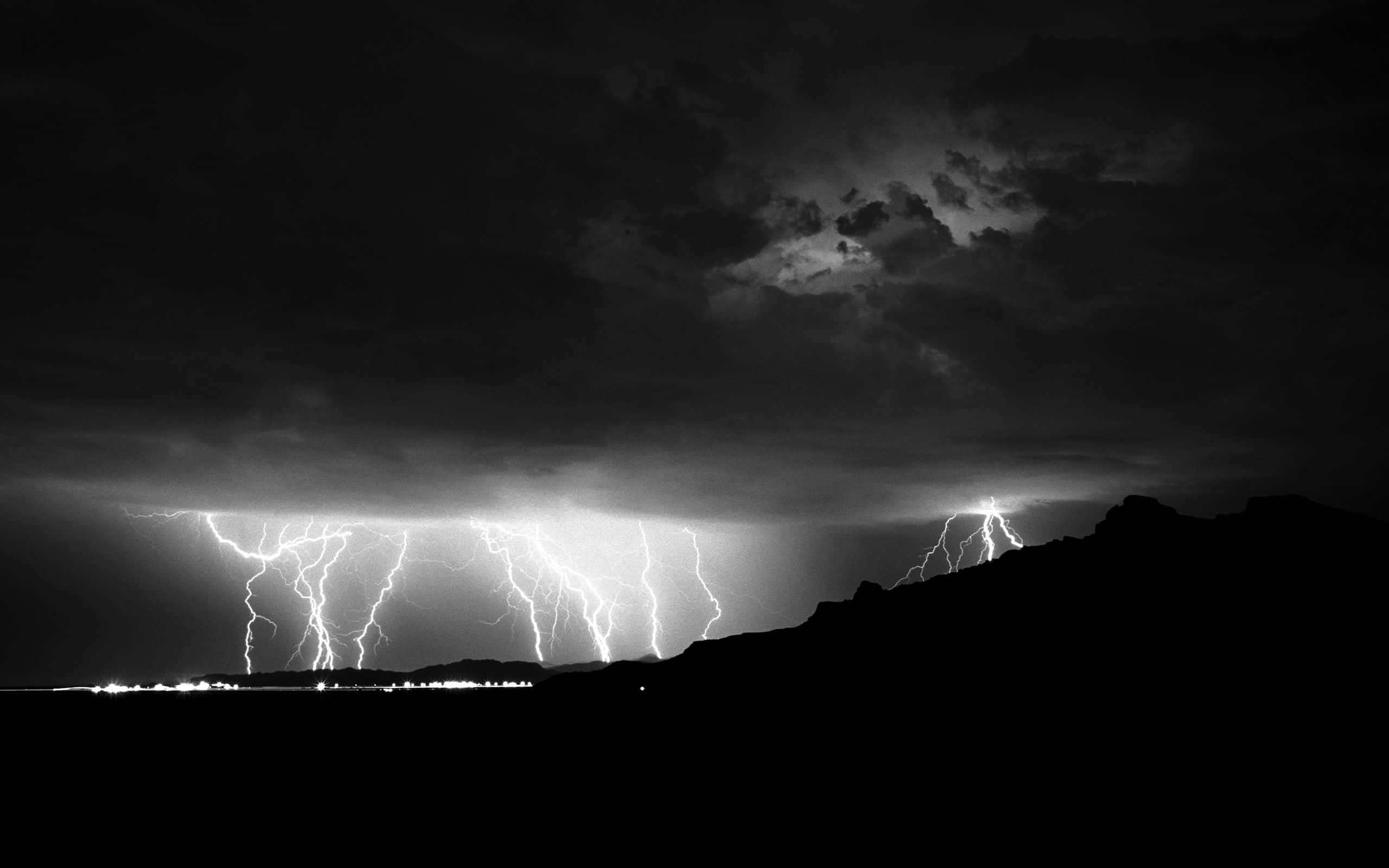 Black And White Sky 桌布 壁紙 — 戲劇性的黑白閃電照亮了黑暗山巒地平線上的暴風雨天空。