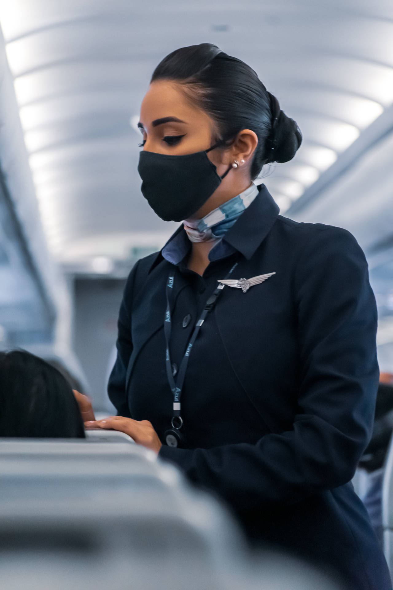 空中服務員戴口罩在飛機上服務乘客