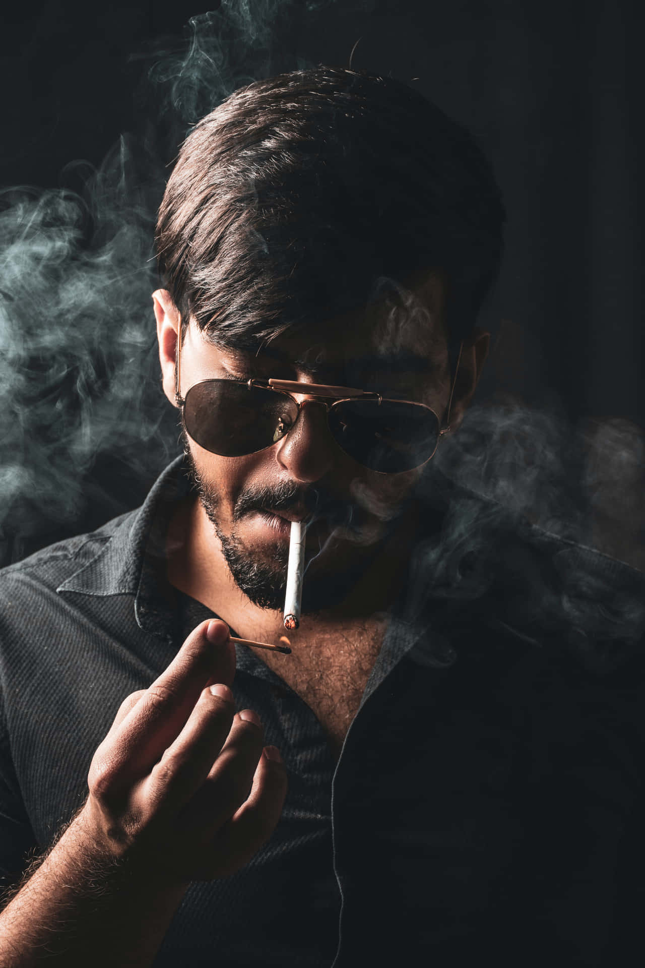 男人戴太陽眼鏡在黑暗煙霧環境中抽煙