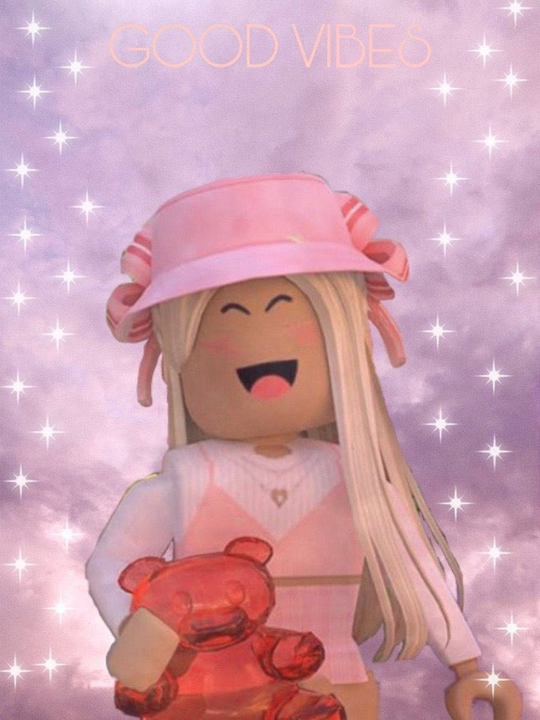 戴粉紅帽子的美學 Roblox 女孩 壁紙 — 一個開心的Roblox頭像，金髮戴粉紅色帽子，在閃爍的紫色天空下抱著紅色泰迪熊，並有'GOOD VIBES'字樣。