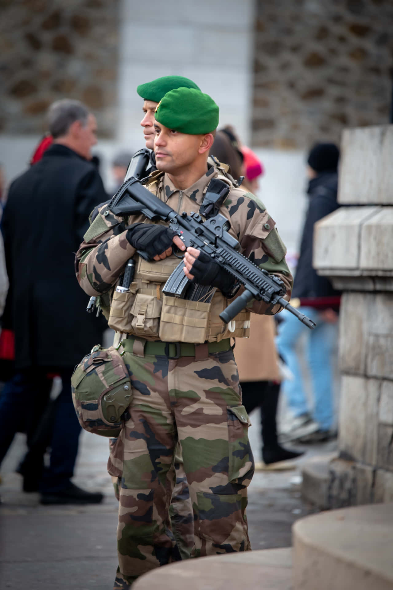 身穿迷彩服的士兵在城市街道上持步槍