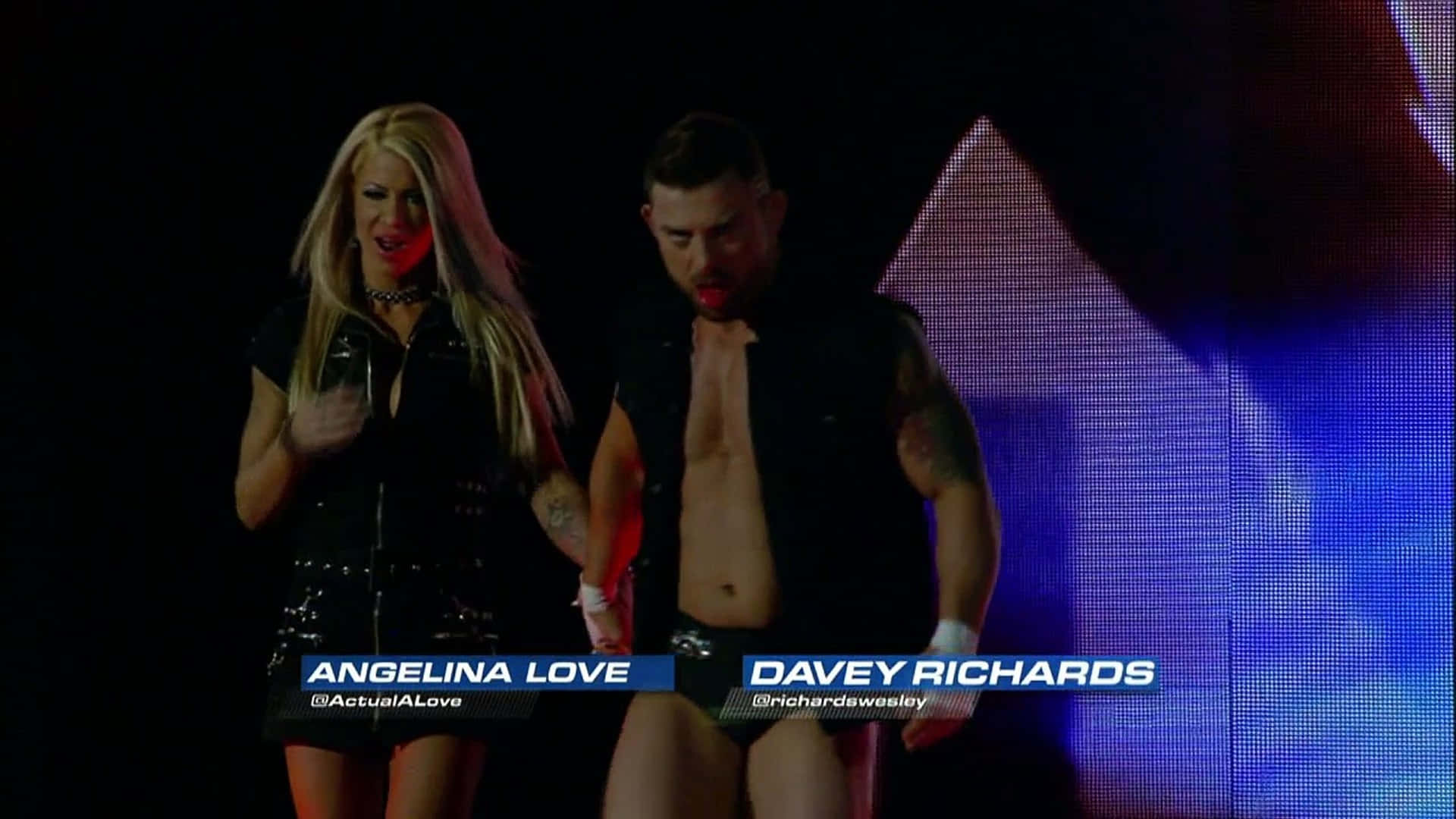 摔角手 Angelina Love 和 Davey Richards 一起在燈光閃耀的舞台上行走。