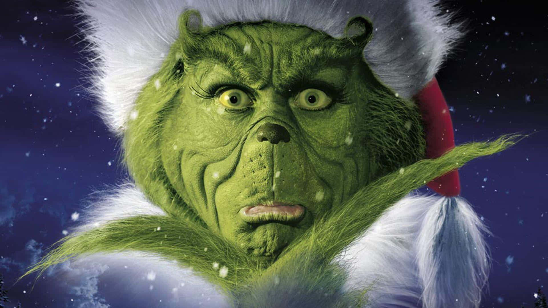 Cute Grinch 桌布 壁紙 — 戴著白色毛邊紅帽子的鬼靈精，在雪夜星空下凝視著。