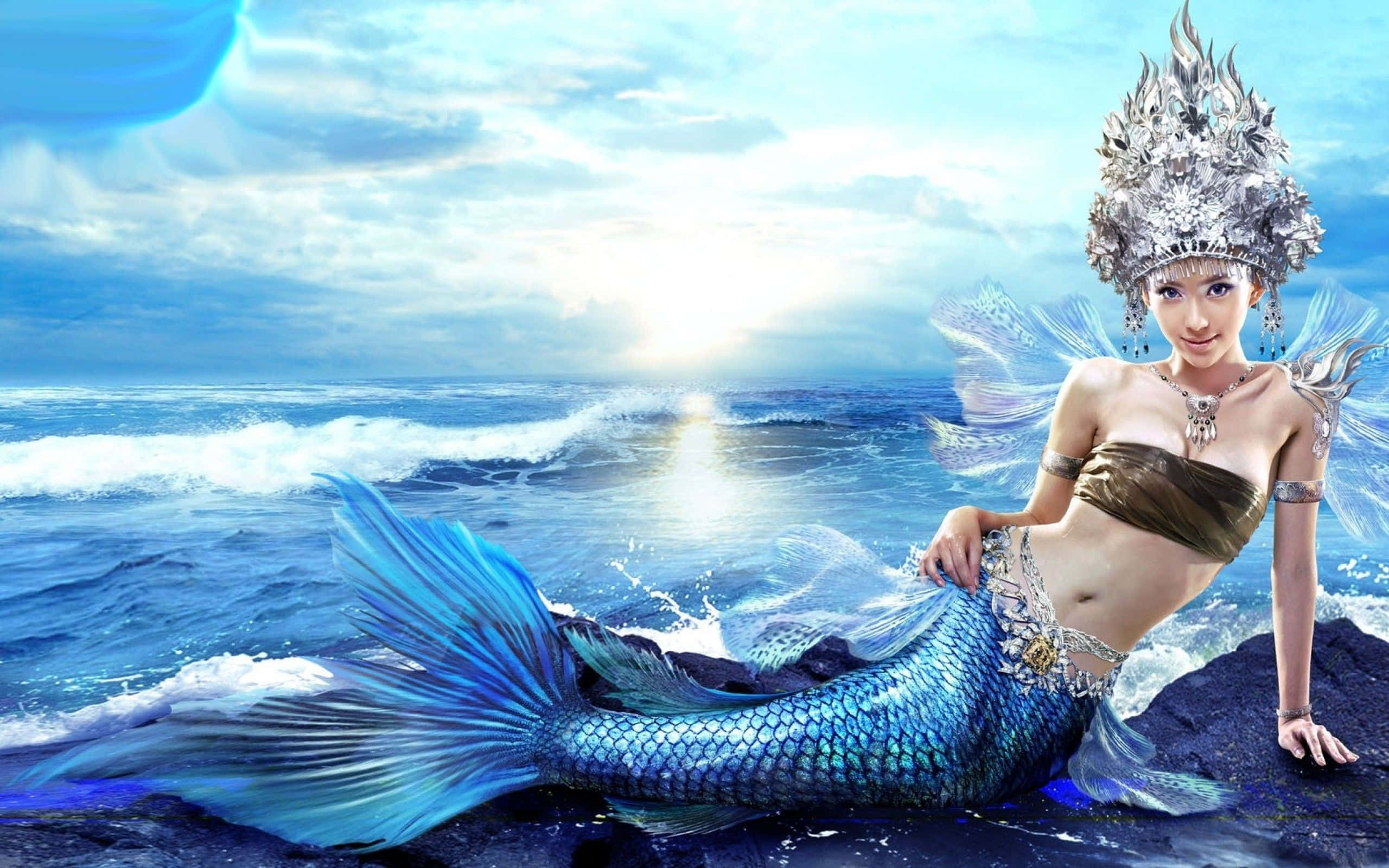 戴著貝殼頭飾的真實美人魚 壁紙 — 一位迷人的美人魚，擁有閃閃發光的藍色尾巴和華麗的銀色皇冠，在日落時優雅地坐在海洋岩石上。