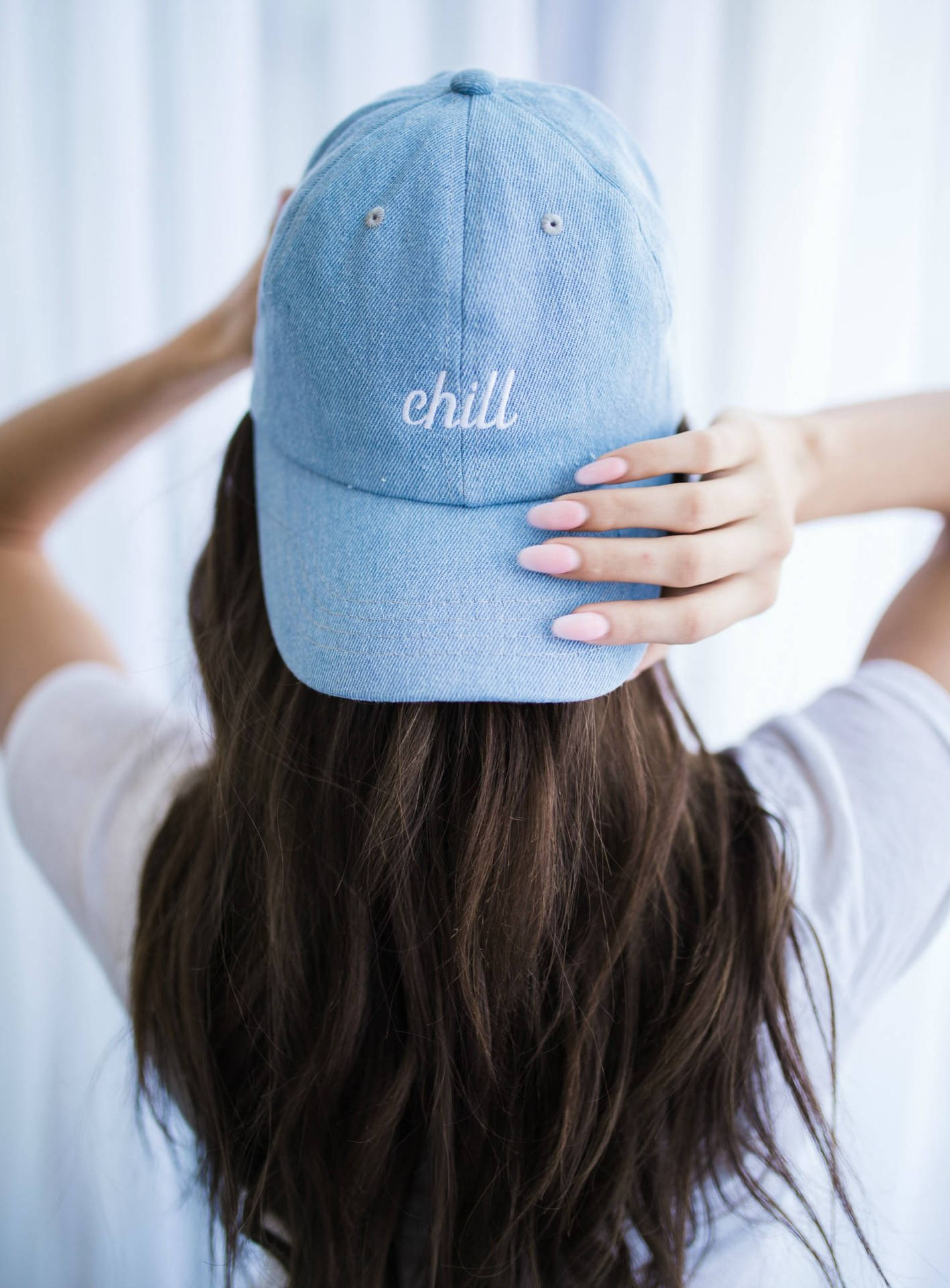 戴著藍色牛仔帽，帽上繡有「chill」的人。