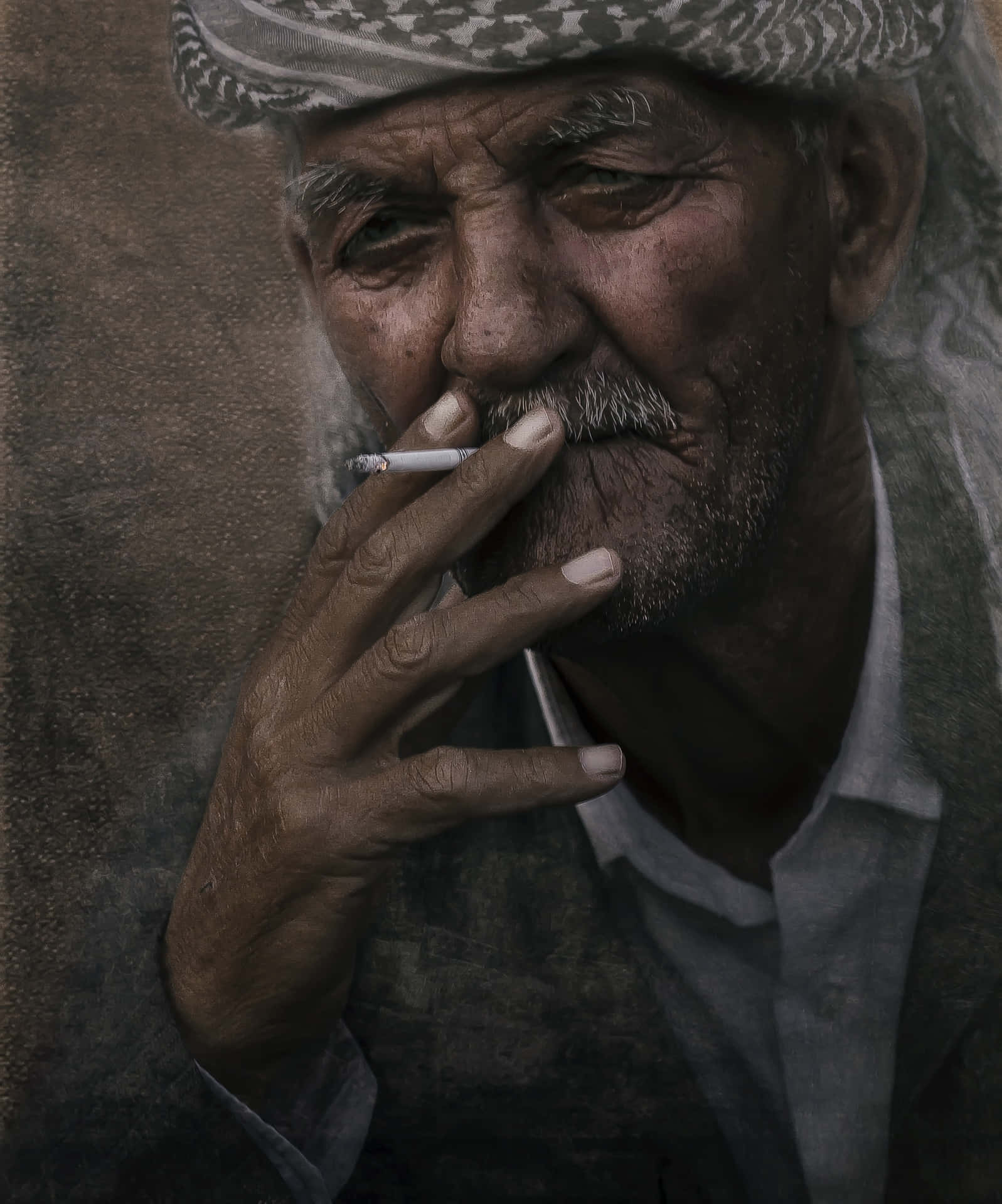 戴著圖案帽子的老人抽煙的特寫。