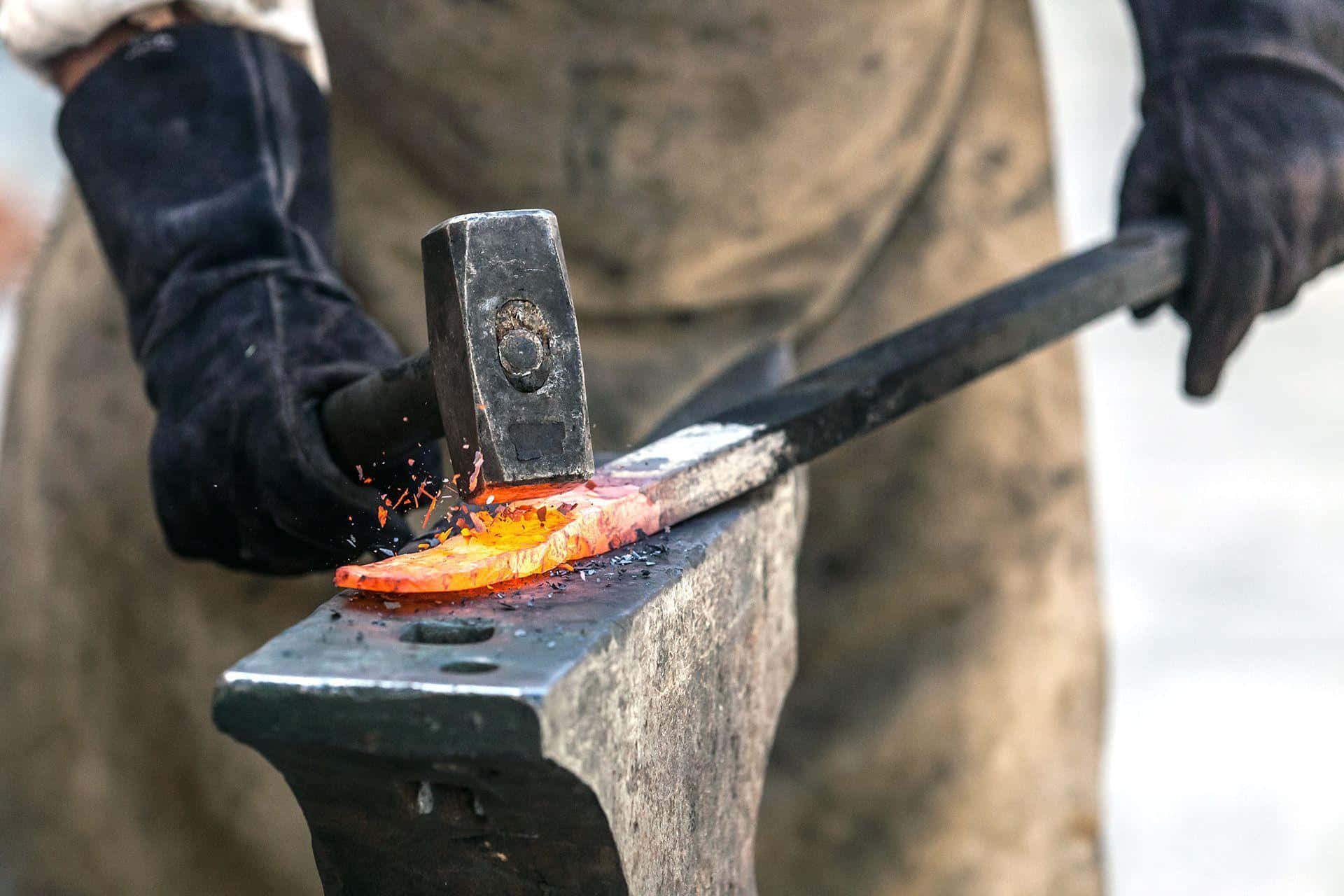 Blacksmith 桌布 壁紙 — 戴黑色手套的鐵匠在石砧上敲打熾熱的橙色金屬，火花四濺的近距離拍攝。