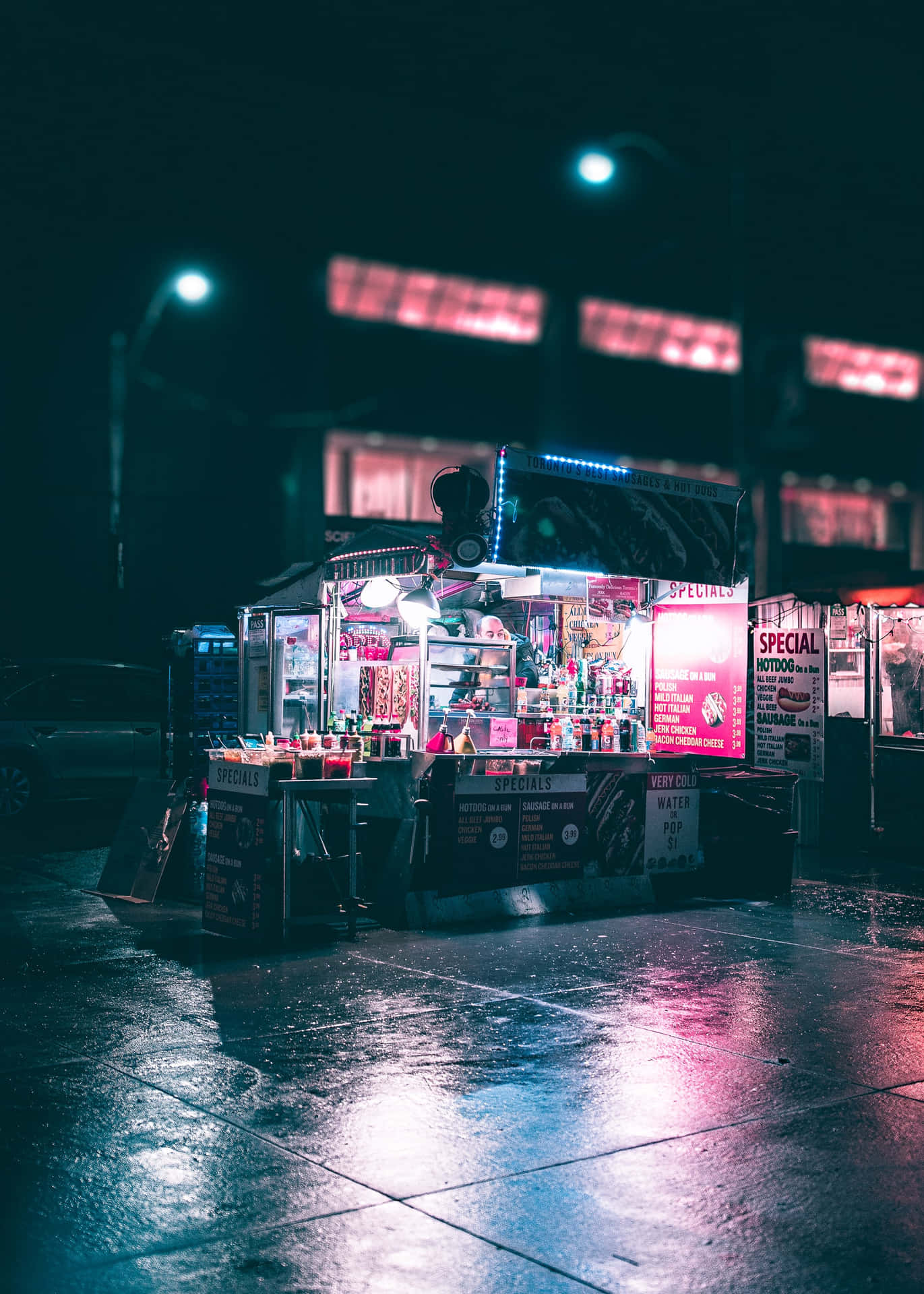 夜晚潮濕的城市街道上，一輛燈光明亮的美食車，帶有霓虹反射。