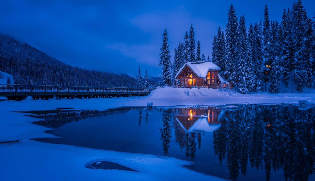 雪地冬日森林暮色中的舒適小屋，發光窗戶與湖中倒影