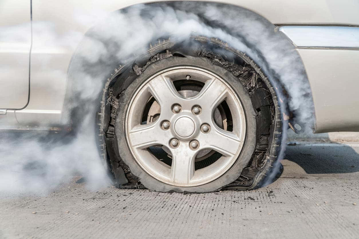 汽車爆胎在瀝青路面上冒煙
