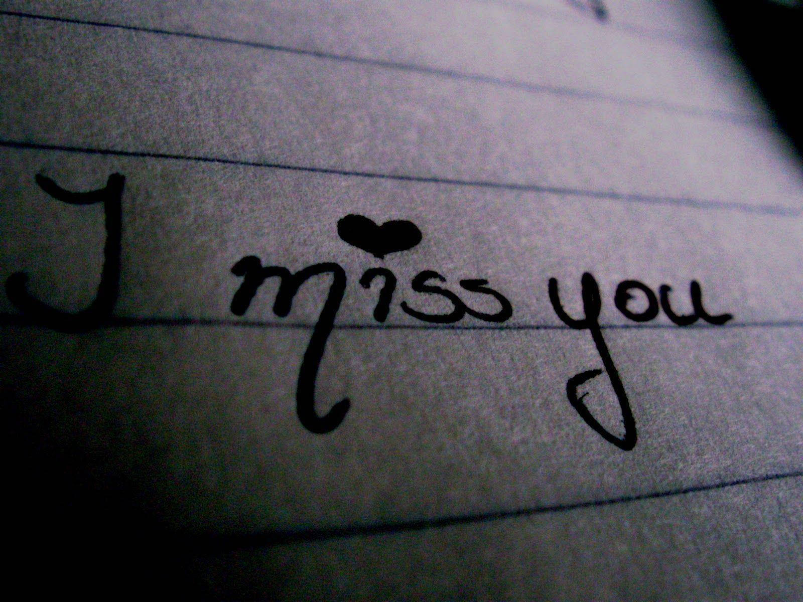手寫「我想你」 壁紙 — 微弱燈光下，橫線紙上手寫文字「I miss you」的特寫，字母「i」上方有一個心形。