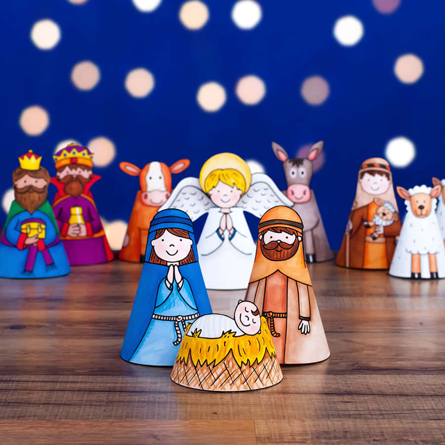 Nativity Scene 桌布 壁紙 — 手工紙剪耶穌誕生場景，木地板上微笑的人物，背景是散景星空夜晚。
