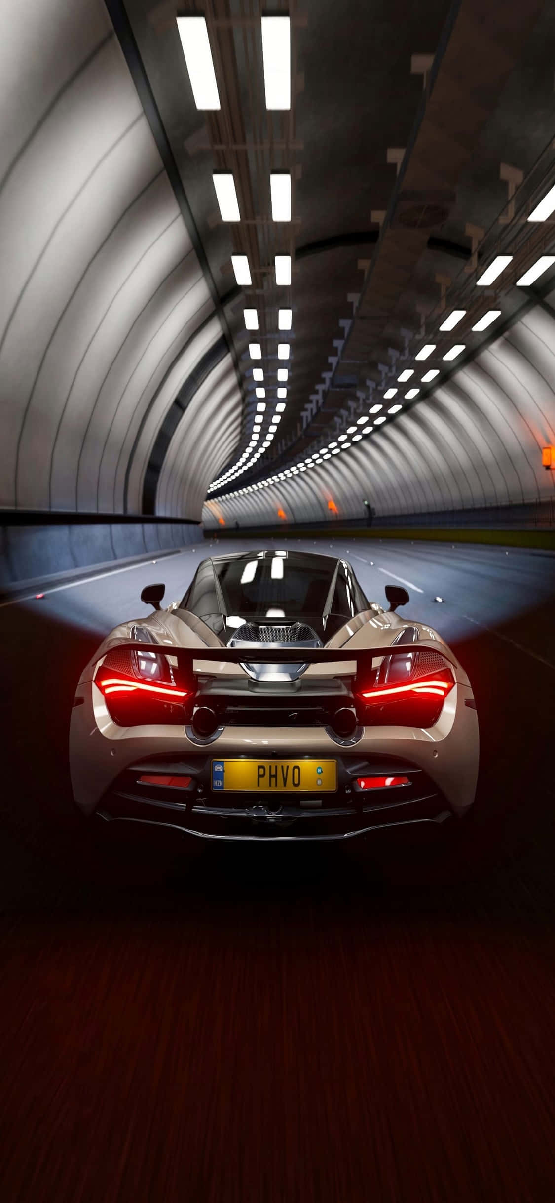 手持 iPhone Xs，感受 McLaren 720s 的澎湃動力 壁紙 — 一輛銀色跑車帶著發光的紅色尾燈，在一個有彎曲白色牆壁的長長照明隧道中飛馳。