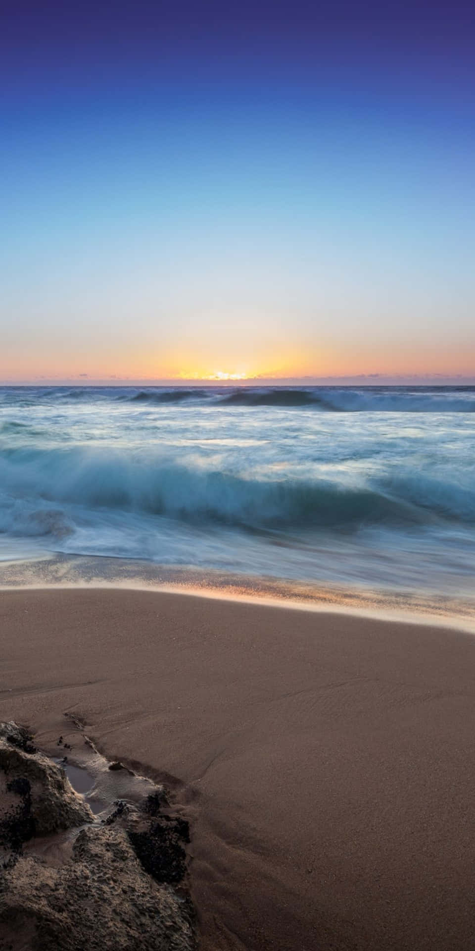 海洋上的夕陽，海浪拍打沙灘