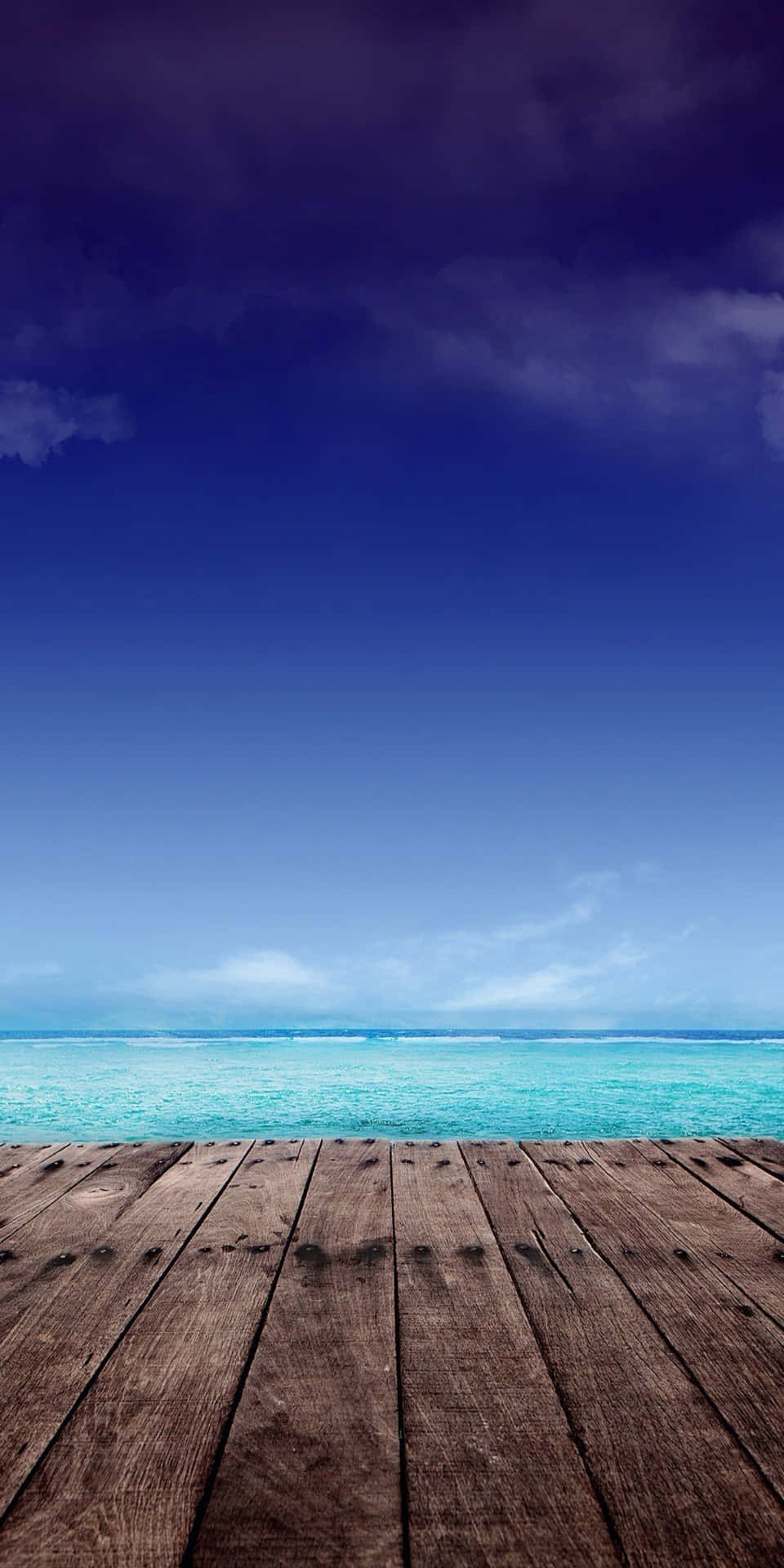 面向綠松石色海洋和藍天白雲的木甲板