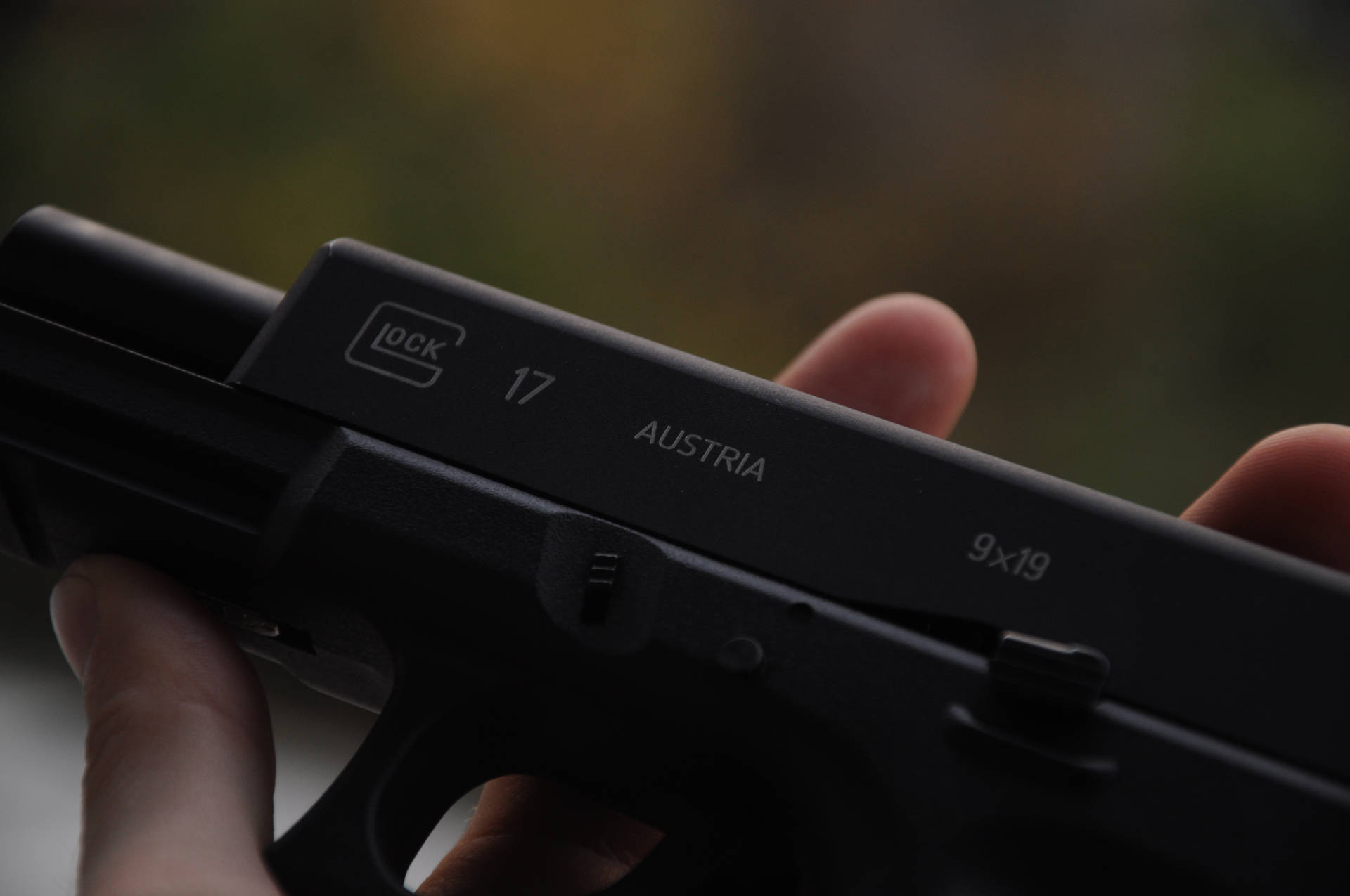 手持黑色 Glock 17 手槍，帶有「Austria」和「9x19」標記。