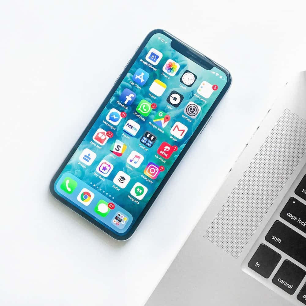 智能手機和筆記本電腦放在乾淨的白色桌子上進行數位工作。