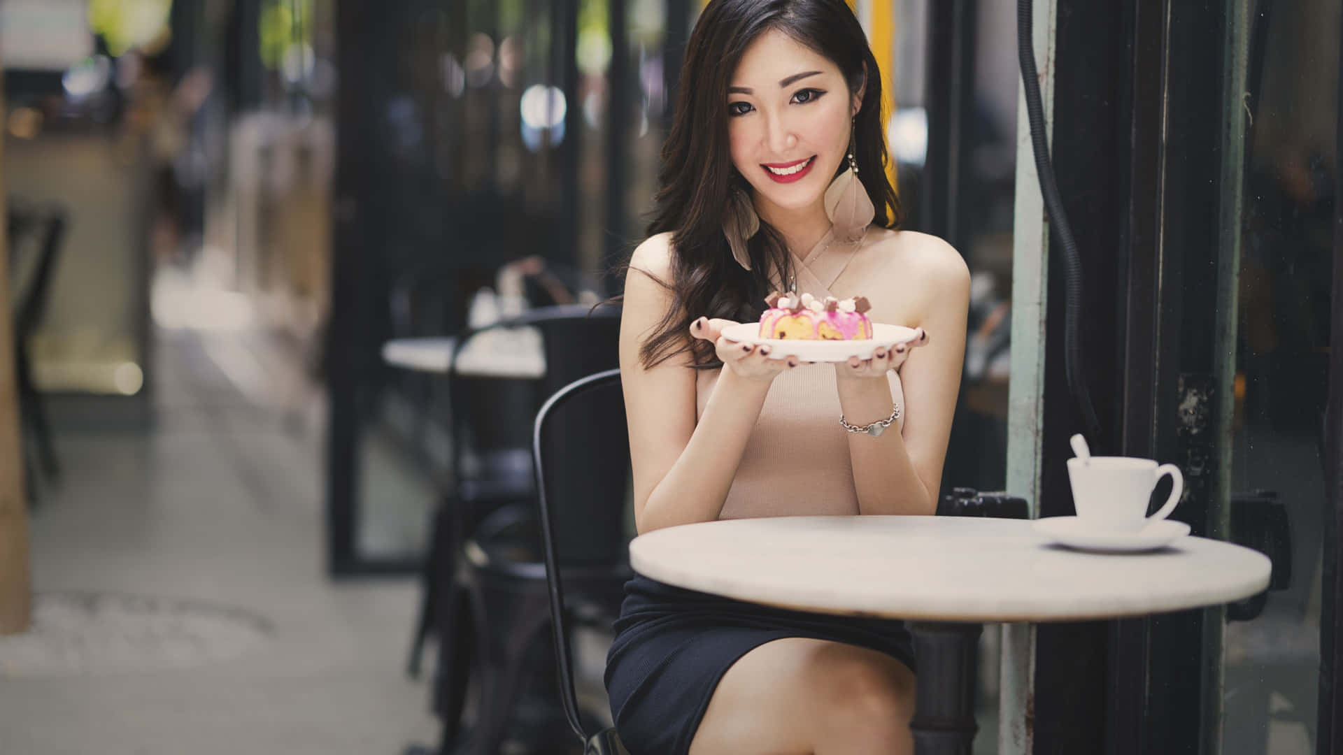 女士在戶外咖啡桌旁享用甜品，配白色杯子