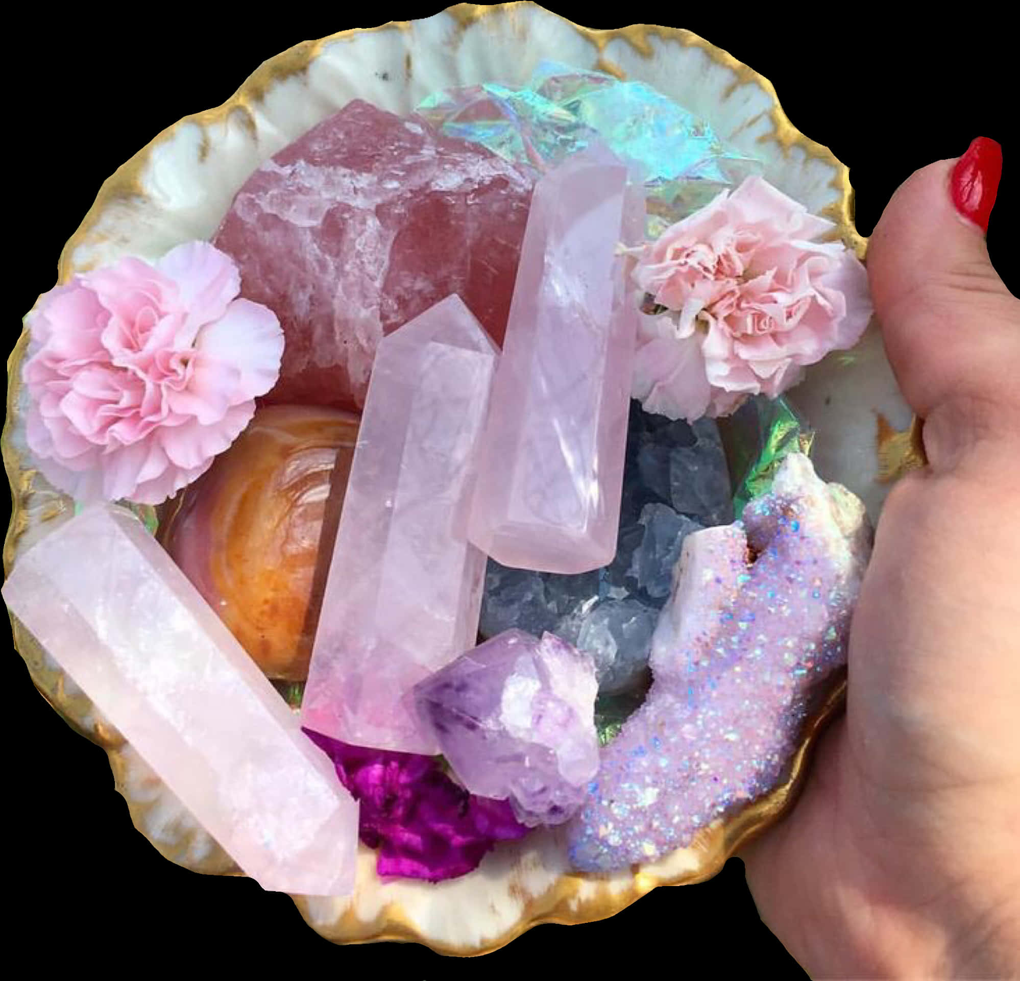 手捧貝殼中的水晶與花朵 壁紙 — 一隻手拿著一個扇貝形的碟子，裡面裝滿了粉紅玫瑰石英晶體、粉紅康乃馨和閃閃發光的晶洞，背景是黑色的。
