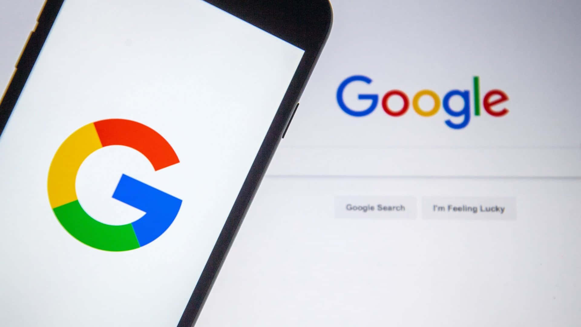 智能手機和電腦屏幕均顯示Google搜尋首頁。