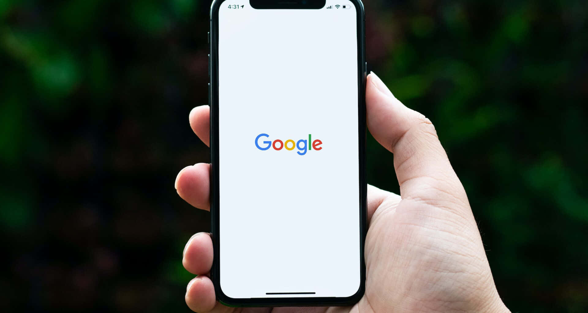 手持智能手機顯示Google搜尋首頁。