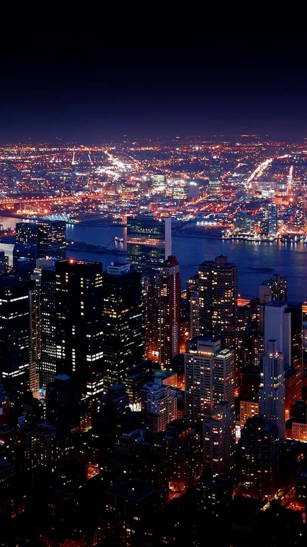 夜晚紐約市嘅航拍景色，有發光嘅建築物同橋樑。