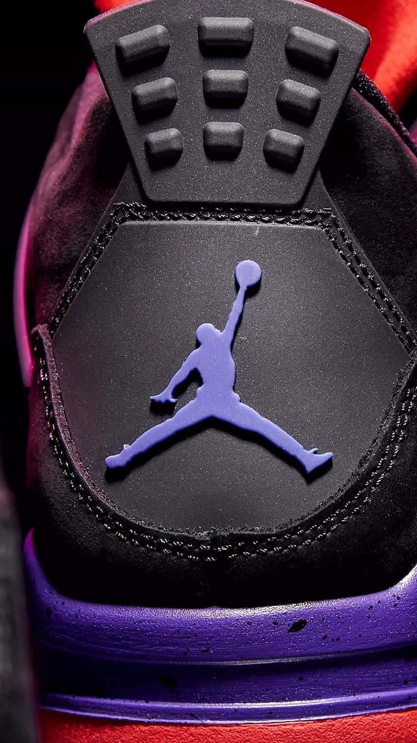 黑色運動鞋上紫色 Jumpman 標誌的特寫，帶有紅色點綴。