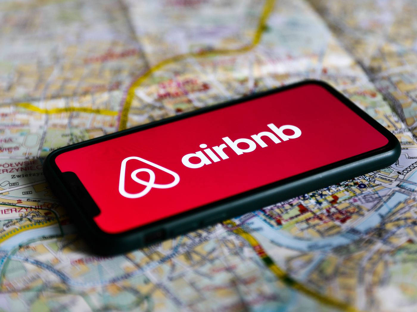 在地圖背景上帶有Airbnb應用程式的智能手機