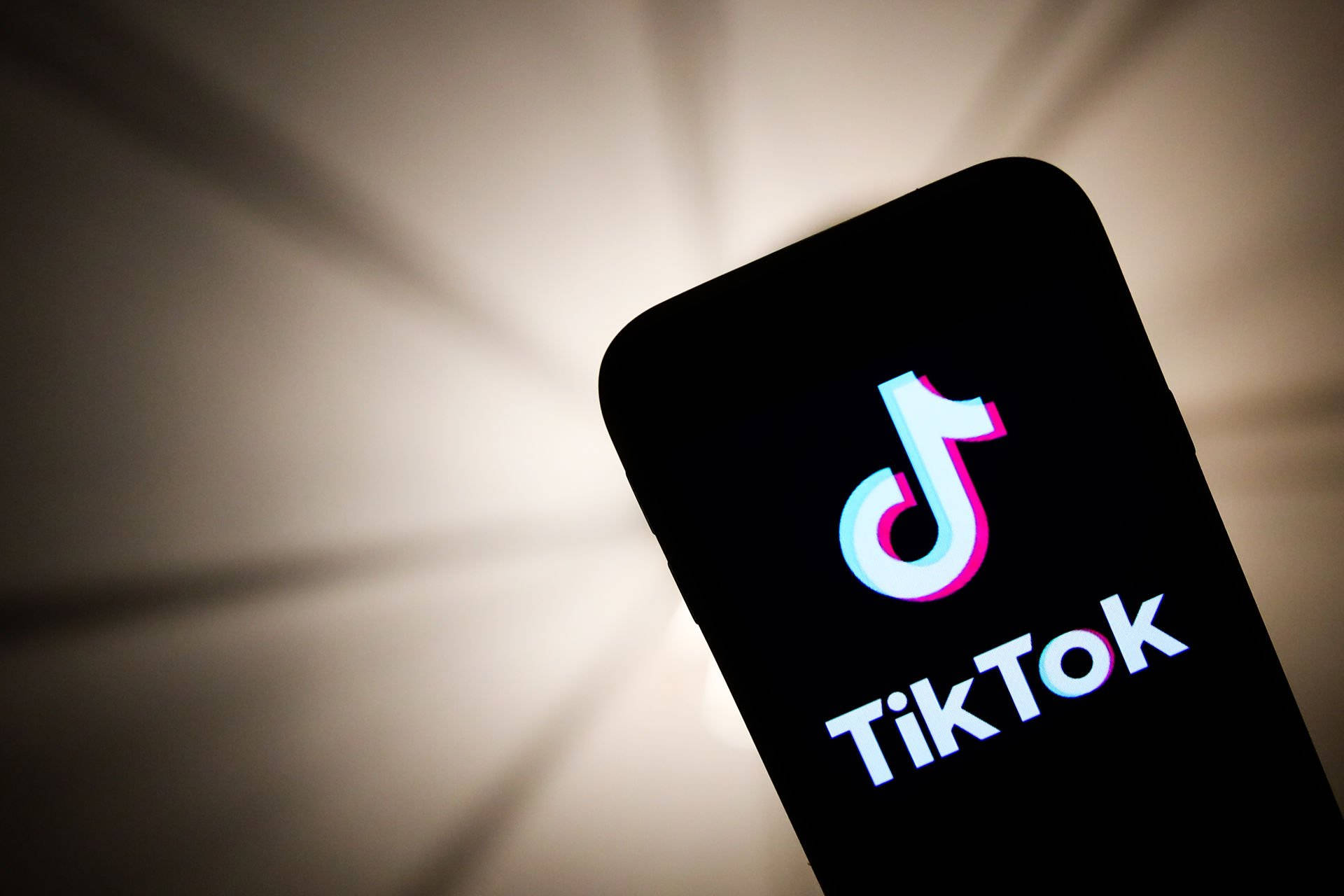 手機特寫，顯示TikTok應用程式標誌，背後有柔和光線。