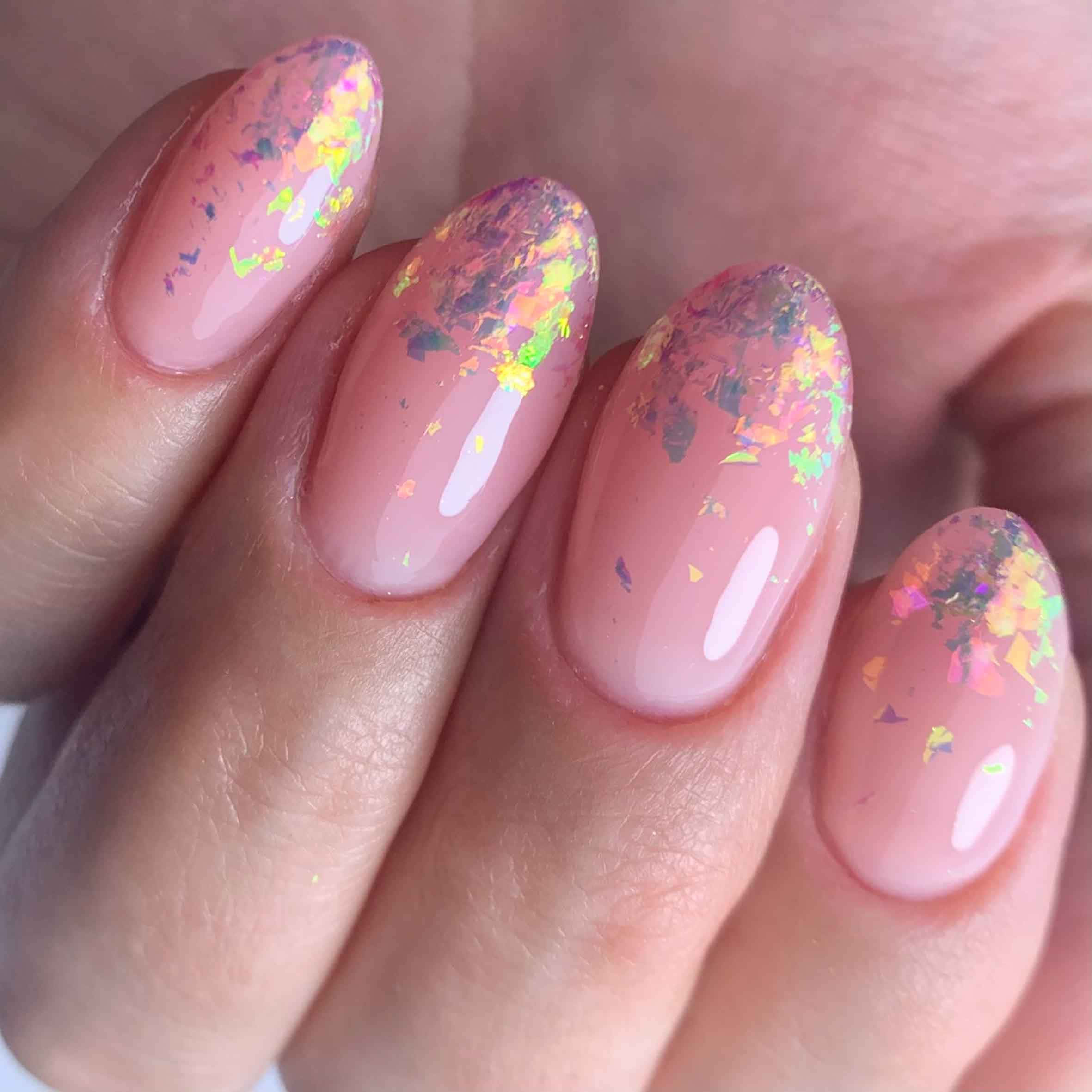 Pink Nail Art 桌布 壁紙 — 手部特寫，帶有光澤粉紅指甲，飾以彩色閃粉片。