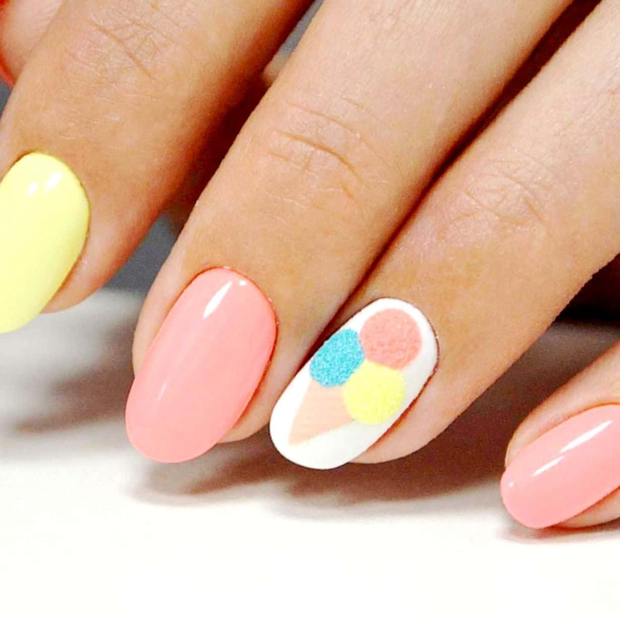 Pink Nails 桌布 壁紙 — 手部特寫，帶有粉彩粉紅色和黃色指甲，其中一隻指甲上有色彩繽紛的雪糕筒設計。