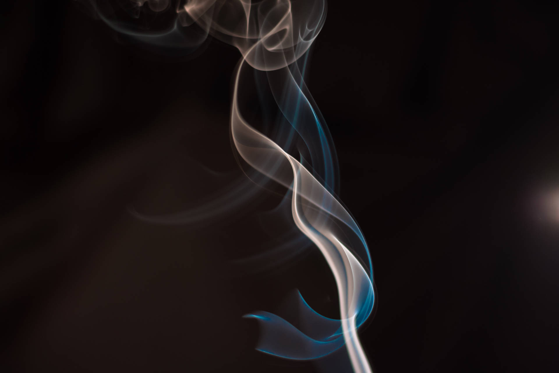 深色背景上的優雅白色和藍色漩渦煙霧