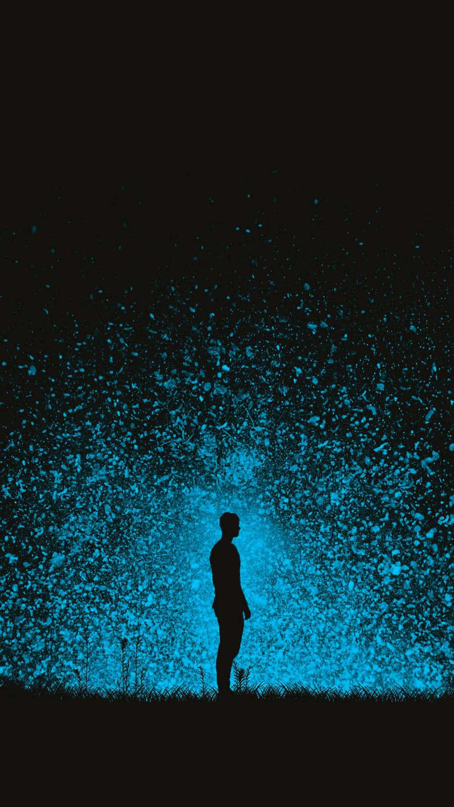 一個人在夜晚獨自站立，藍色發光粒子從地面升起。
