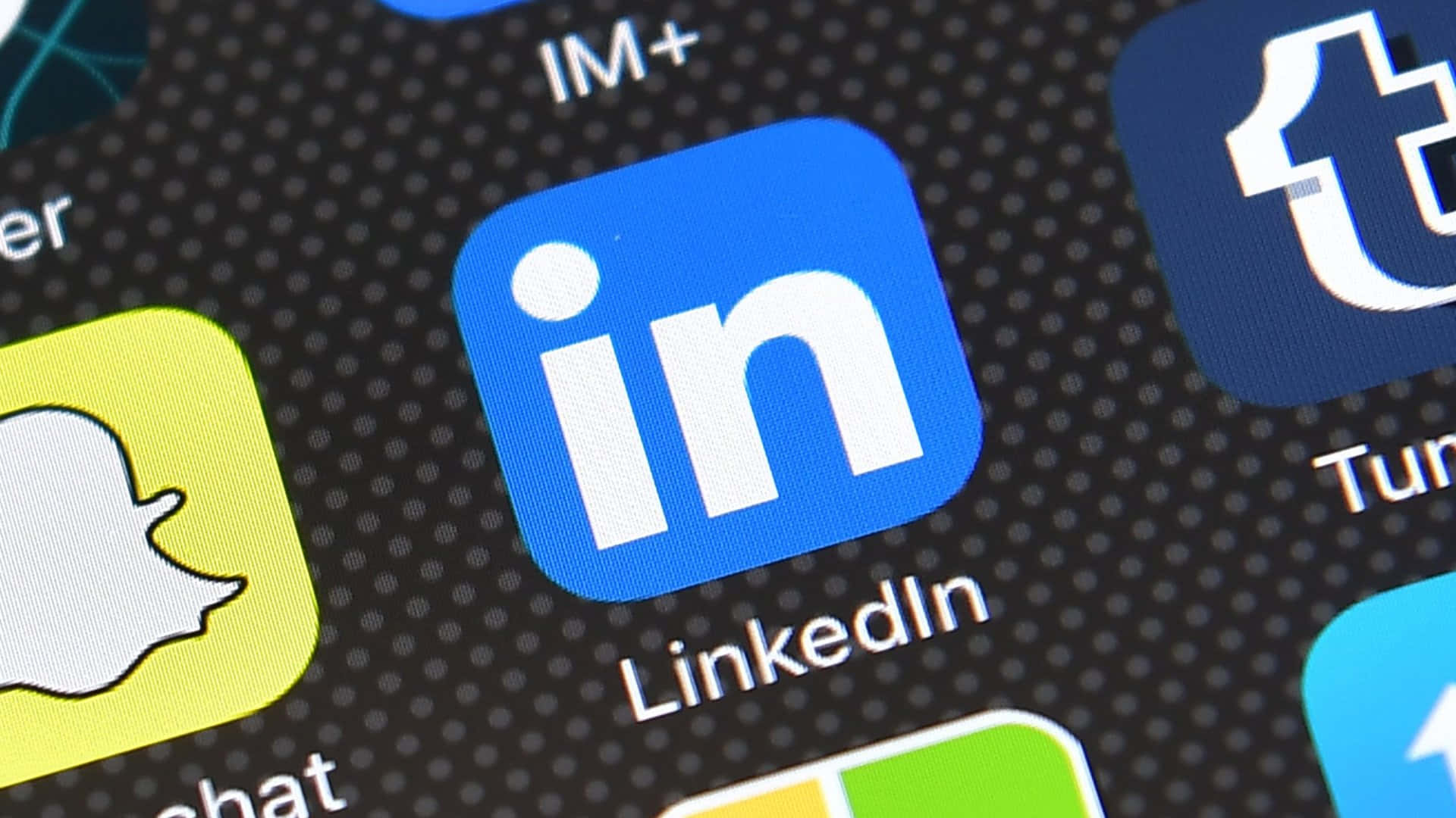 打開你的網絡 壁紙 — 智能手機屏幕特寫，顯示LinkedIn應用程式圖示被其他社交媒體應用程式包圍。
