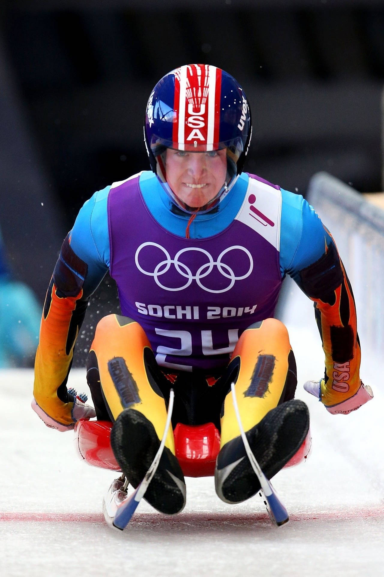 美國雪橇運動員在索契2014年冬季奧運會上沿著冰道飛馳。