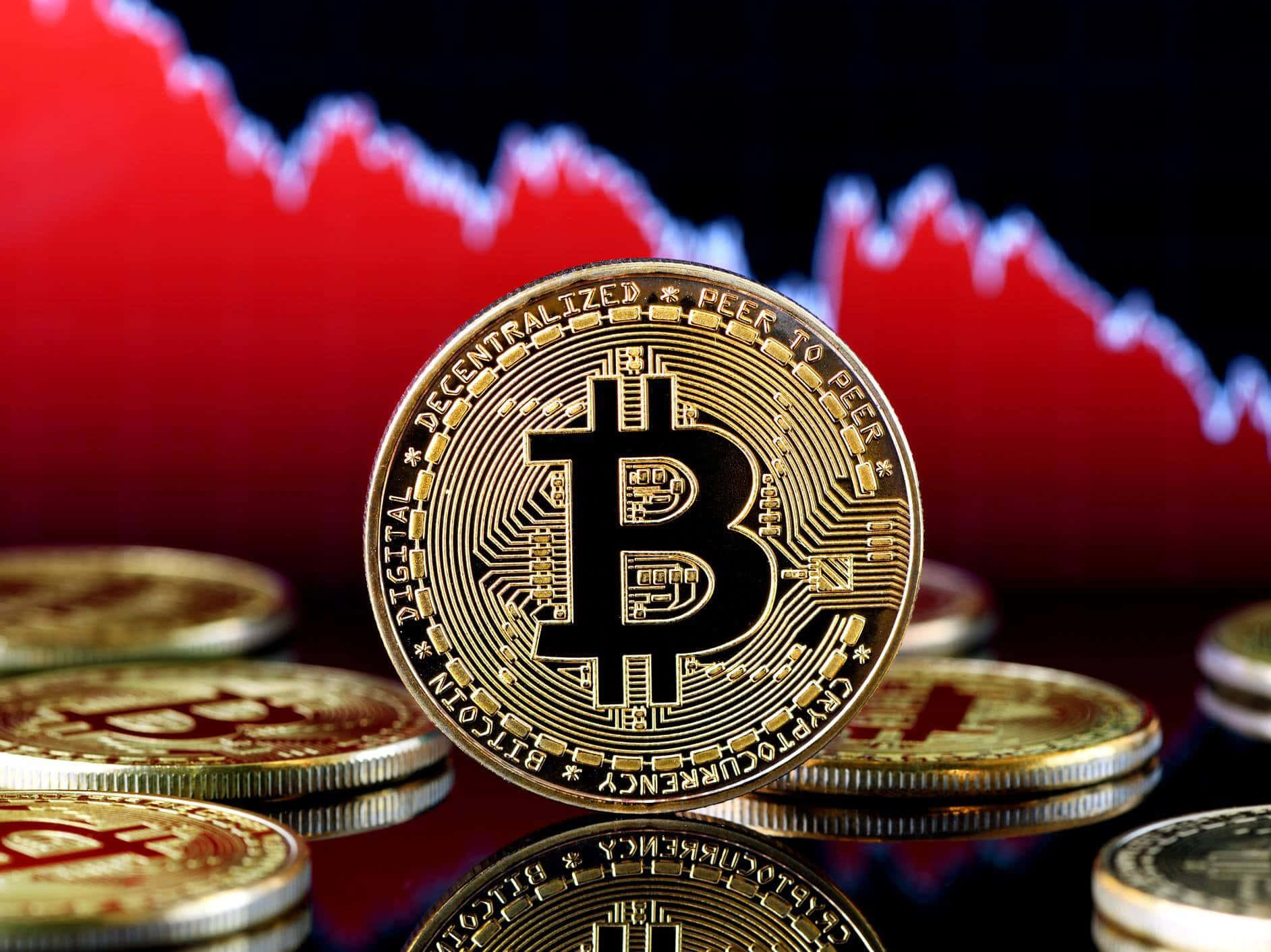 投資比特幣，參與數位貨幣革命 壁紙 — 金色比特幣硬幣排列在反光表面上，背景有紅色下跌的股票圖表。