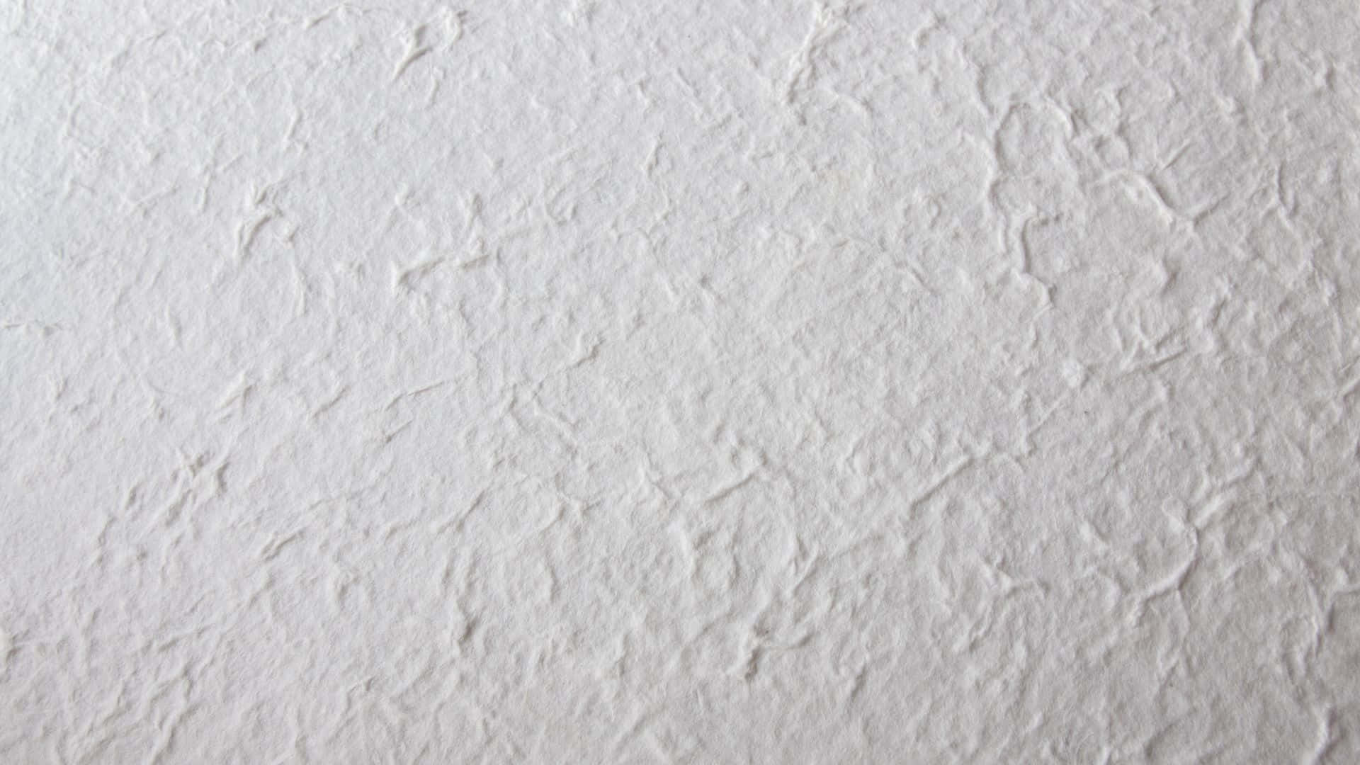 抽象粉紅色紋理背景 壁紙 — 白色紋理牆壁的特寫，帶有微妙的壓花圖案和柔和陰影。