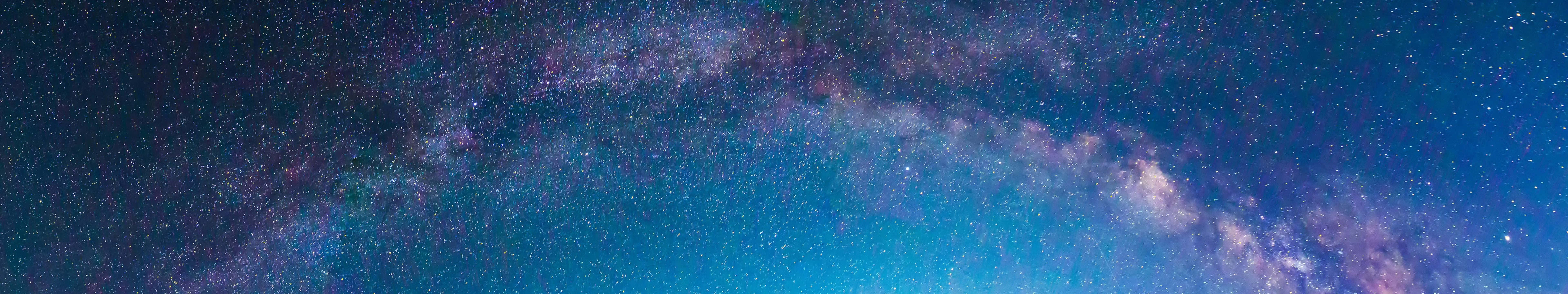 銀河系在深藍色的夜空中拱起，佈滿了星星。