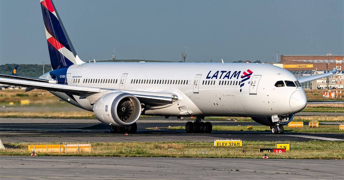 LATAM波音787夢想客機在機場停機坪上，帶有跑道標記和背景建築物。