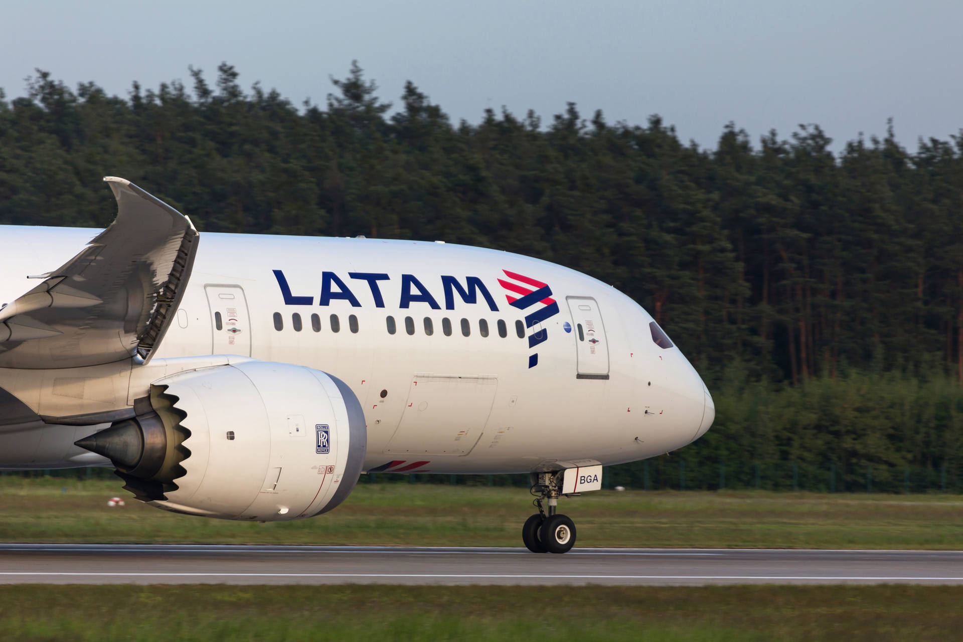 LATAM飛機在跑道上，背景為森林，日間