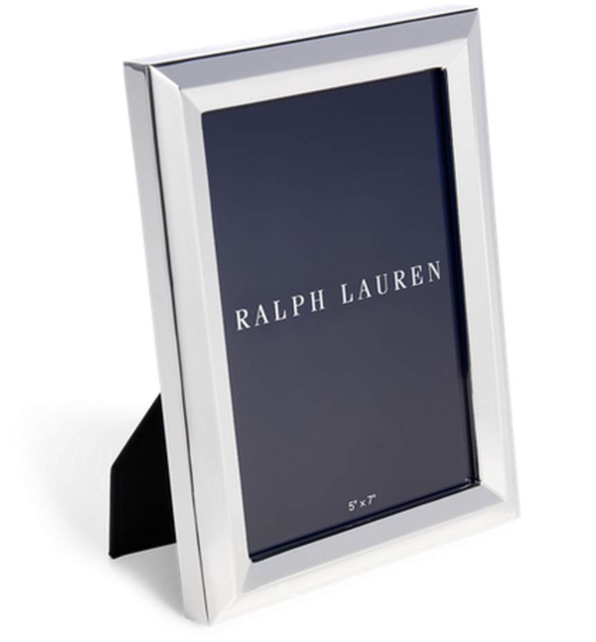 拉夫勞倫品牌相框 壁紙 — 一個時尚的銀色 Ralph Lauren 相框，帶有深藍色內嵌，直立於一個有紋理的灰色支架上，背景為黑色。