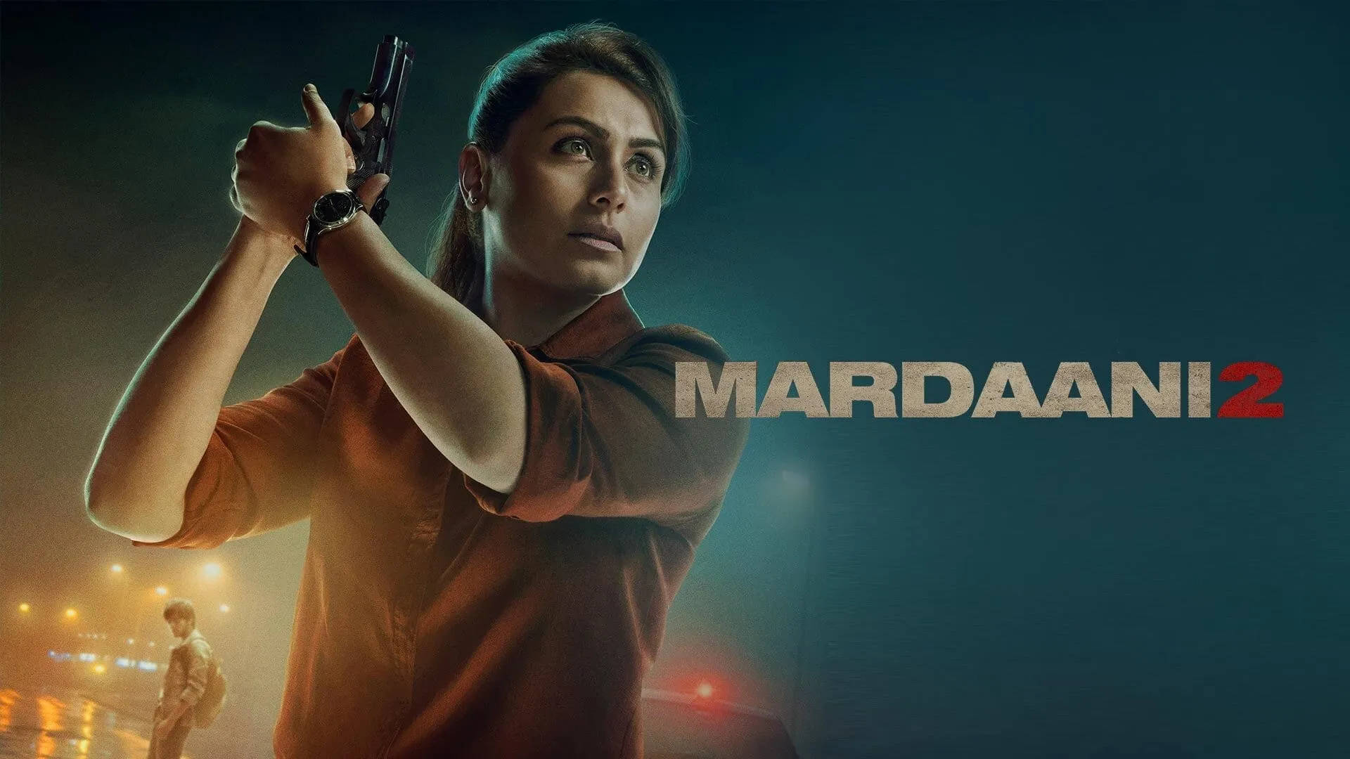 拉妮·穆克吉《Mardaani 2》海報 壁紙 — 一位堅定的女性穿著橙色襯衫，在夜晚用手槍瞄準，身後的城市燈光閃爍。