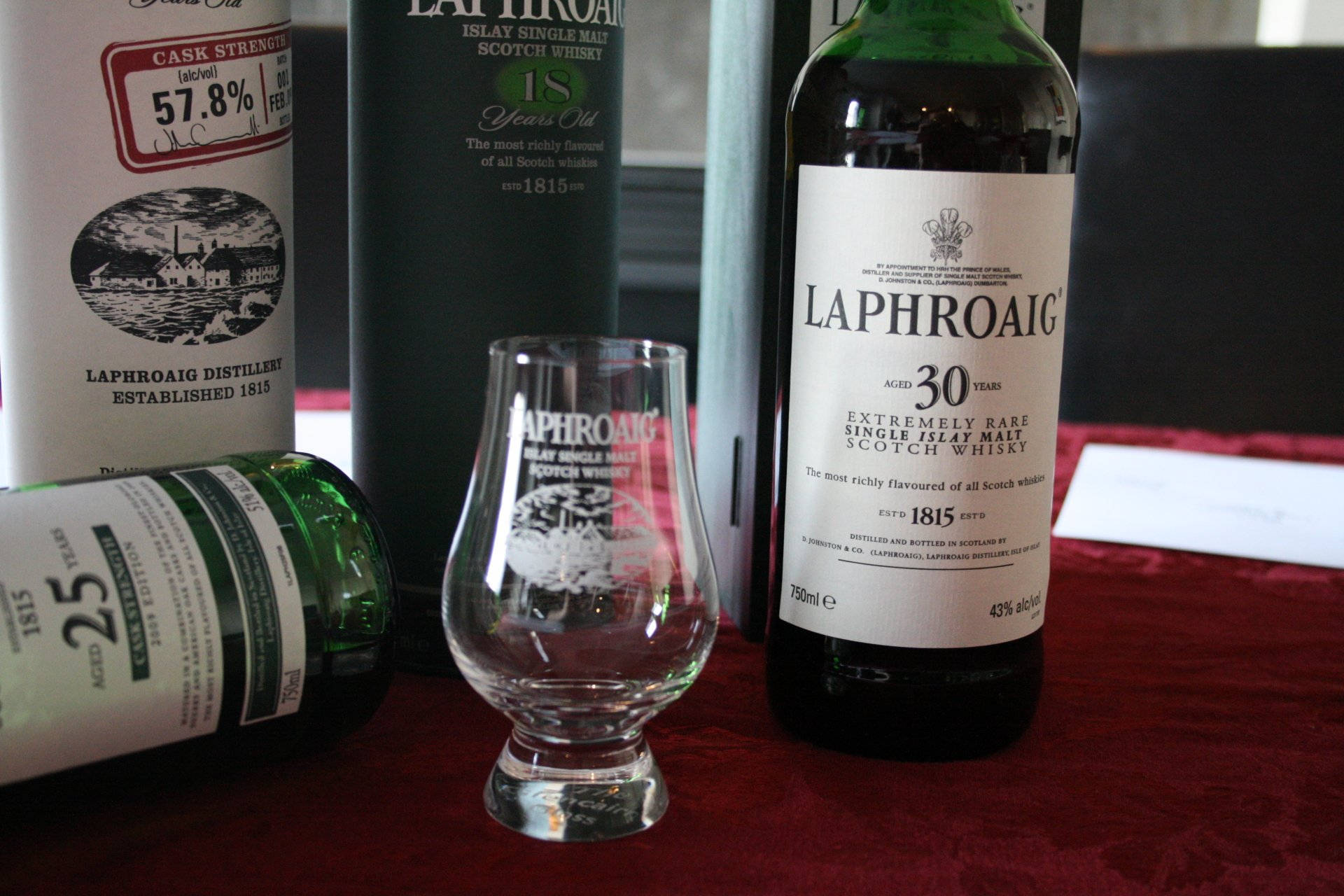 奢華Laphroaig威士忌瓶和品酒杯在紅色天鵝絨上。