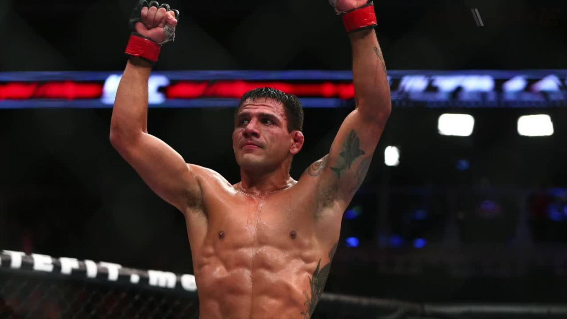 MMA鬥士在八角籠中舉起拳頭慶祝勝利。