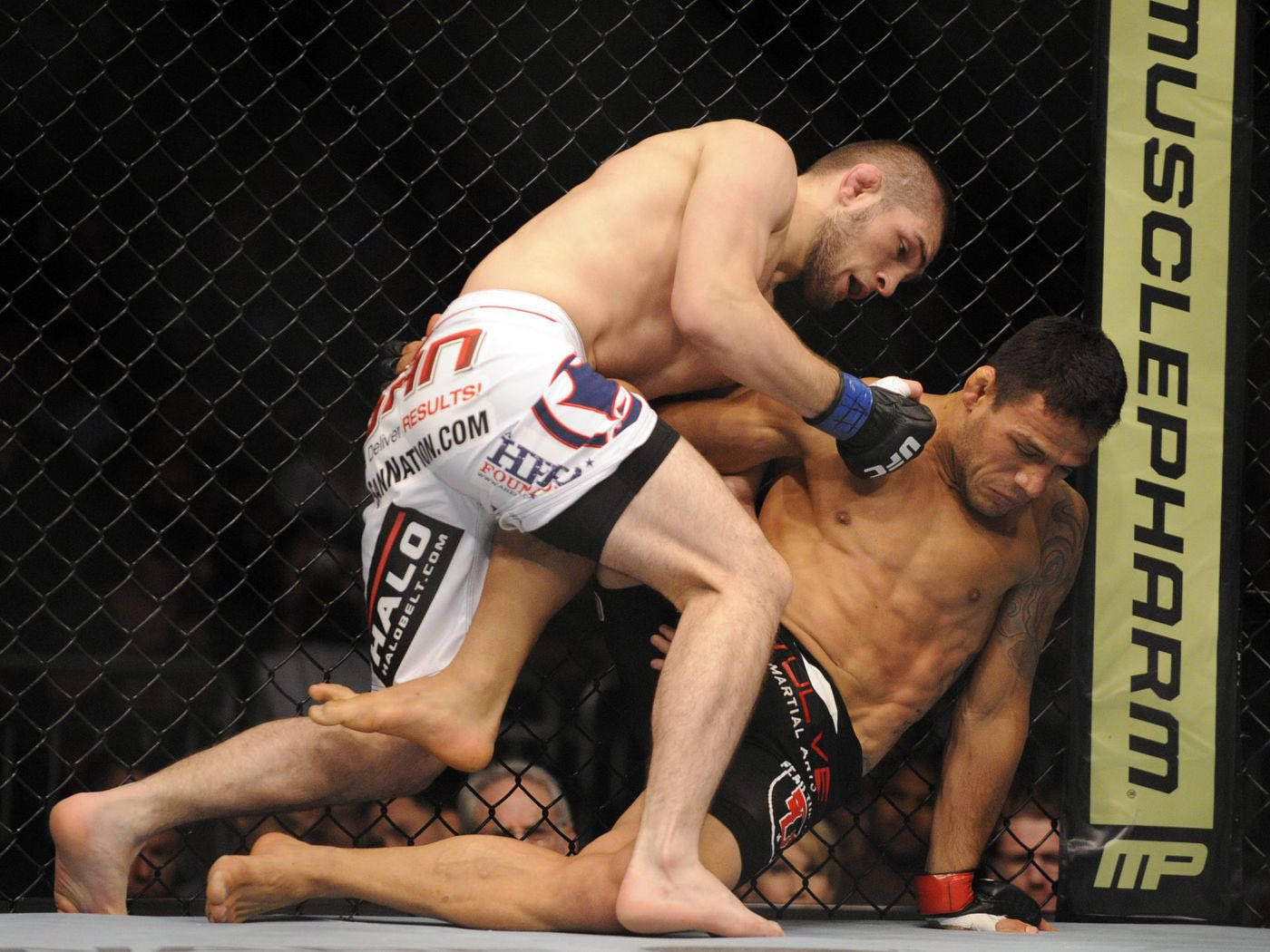 兩名男性MMA拳手在八角籠內進行比賽時纏鬥。