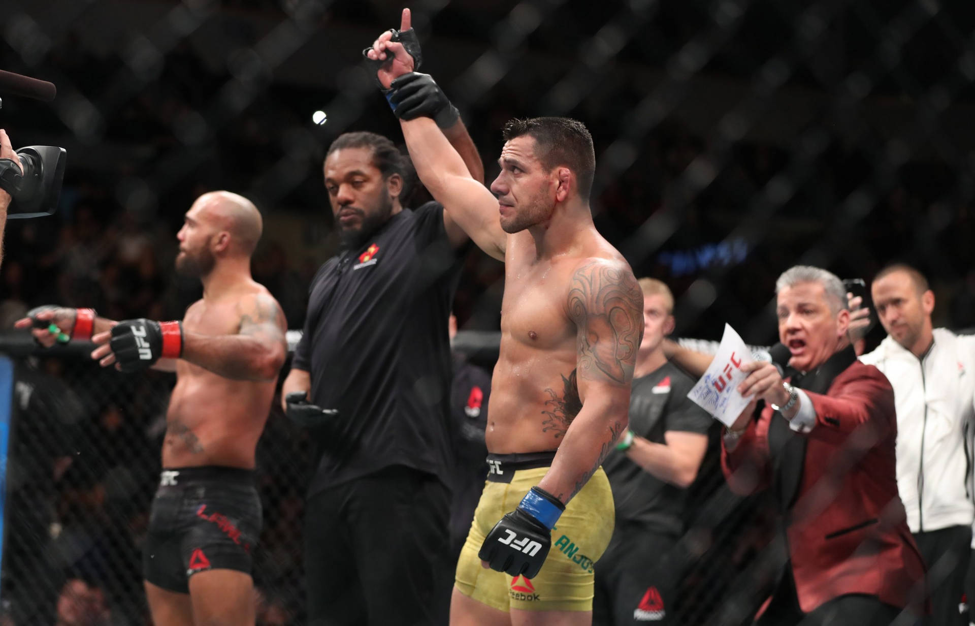 UFC拳手在八角籠內慶祝勝利，裁判和評論員作出反應。