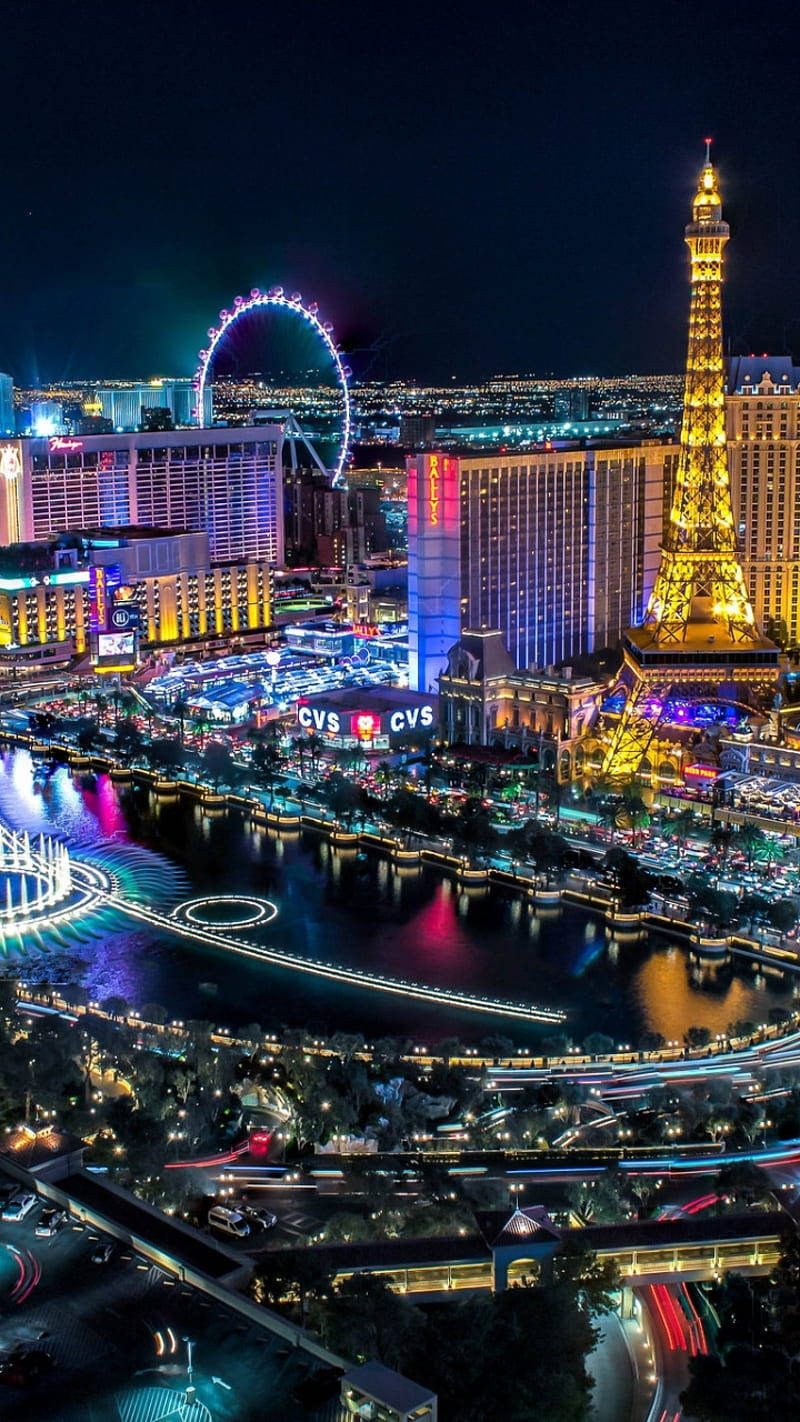 Eiffel Tower 桌布 壁紙 — 拉斯維加斯令人眼花繚亂的夜間鳥瞰圖，展示了拉斯維加斯大道上燈火通明的艾菲爾鐵塔複製品和高滾輪摩天輪。